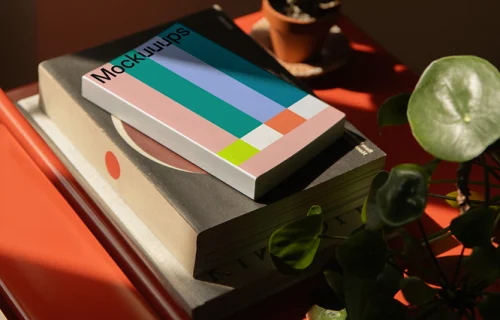 Paperback mockup on a red metal shelf with plants