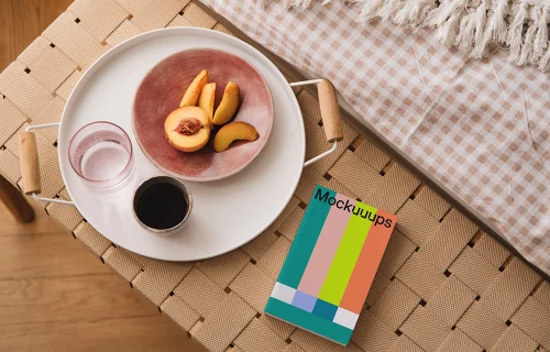 Paperback mockup on a woven bench with a breakfast tray