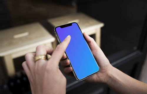 Pointing on iPhone X mockup in front of the shop