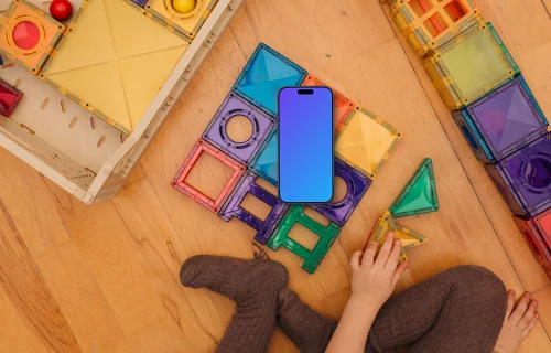 Smartphone mockup with colorful toy blocks and child's hands