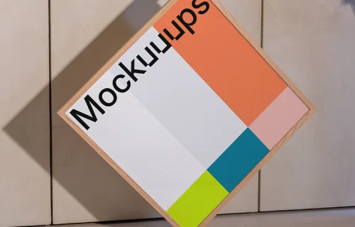 Square wooden frame mockup held against a textured wall