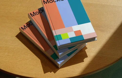 Stacked B-format book mockup on a sunlit wooden table