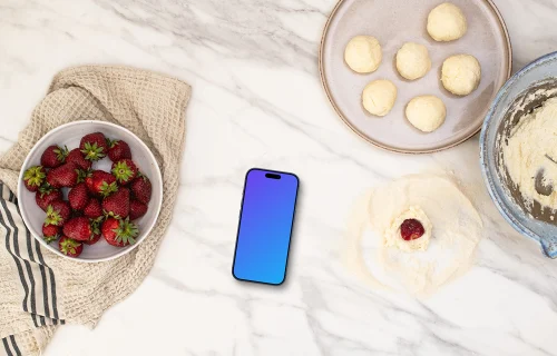Strawberries and sweets next to the iPhone mockup