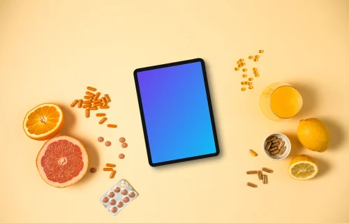 Tablet surrounded by pills and citrus fruits