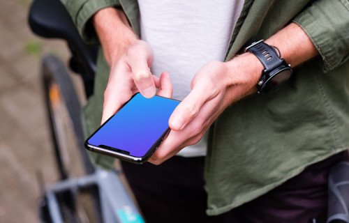 Typing on an iPhone 11 Pro mockup whilst stood with a bike