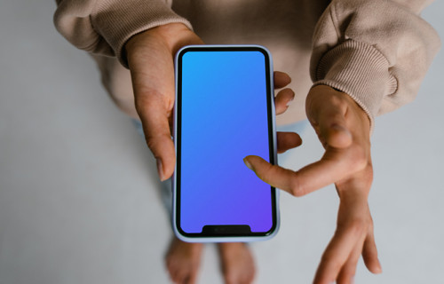 User in brown sweater scrolling through iPhone mockup