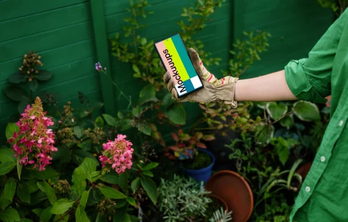 Woman holding a phone in garden gloves mockup