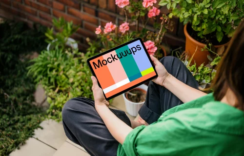 Woman holding an iPad Air in garden full of plants