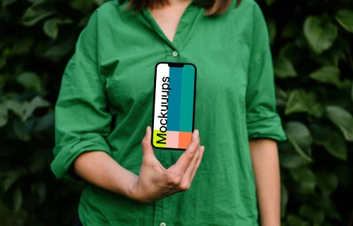 Woman holding an iPhone 13 mockup in green theme