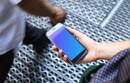 Woman holding iPhone 6s mockup on a bridge