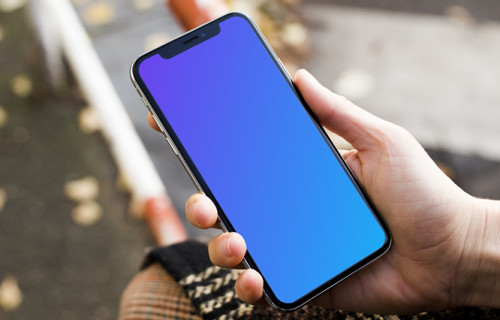 Woman sitting and holding iPhone X mockup