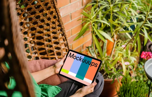 Woman sitting on a hammock while holding an iPad Air mockup