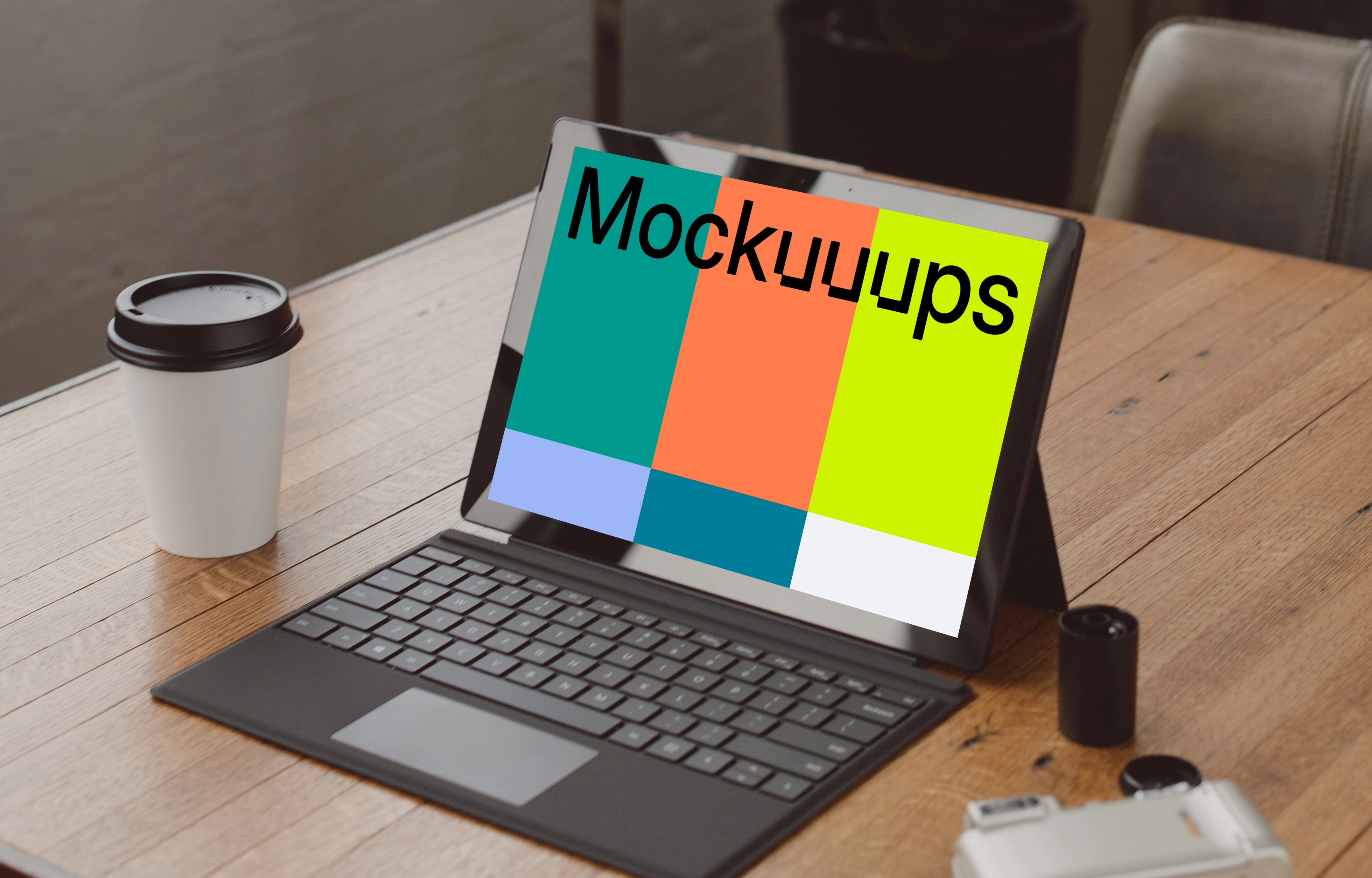 Black Microsoft Surface laptop mockup on a table beside a cup of coffee 