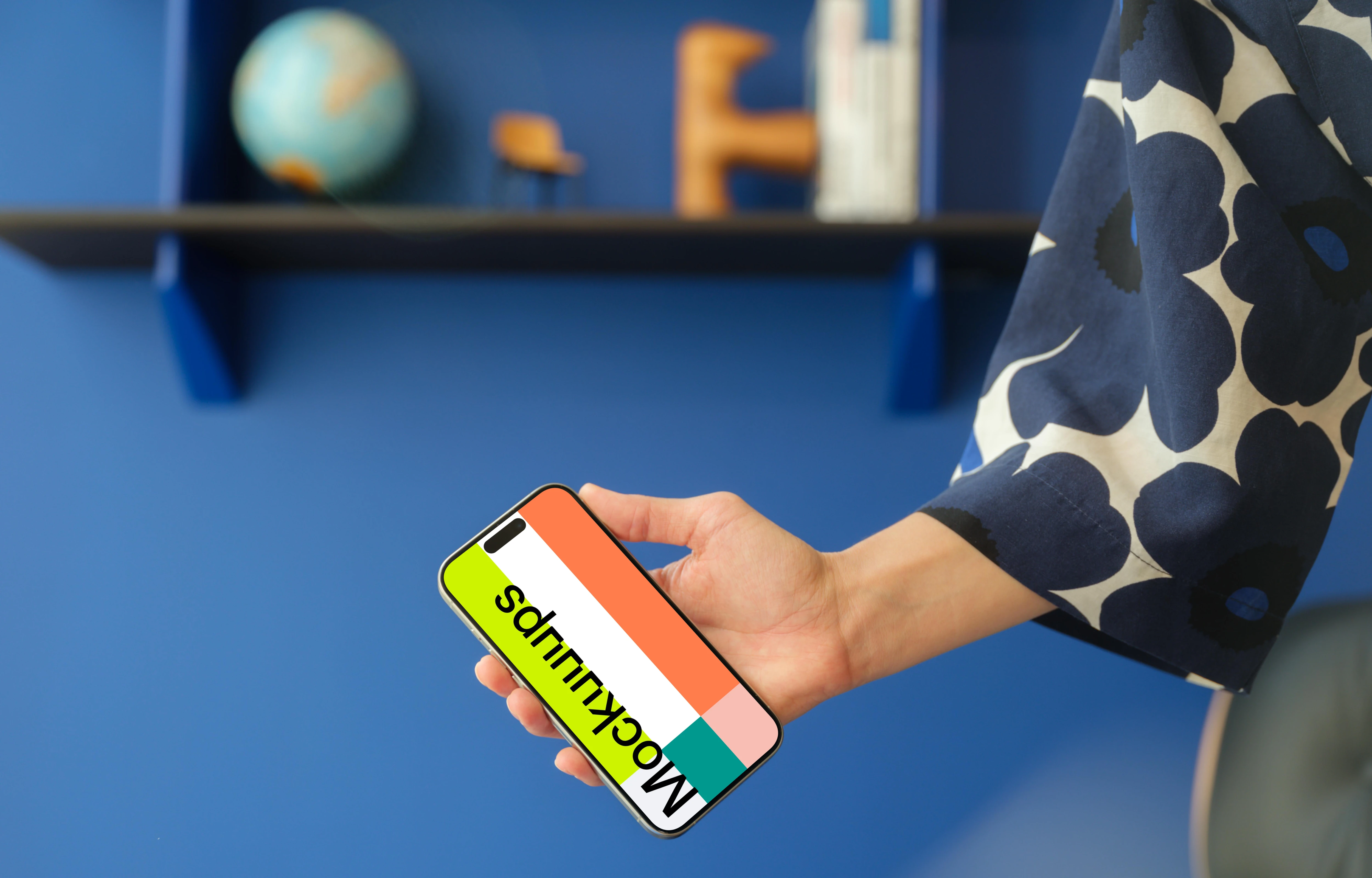 iPhone 15 Pro mockup in a woman's hand against a modern blue wall