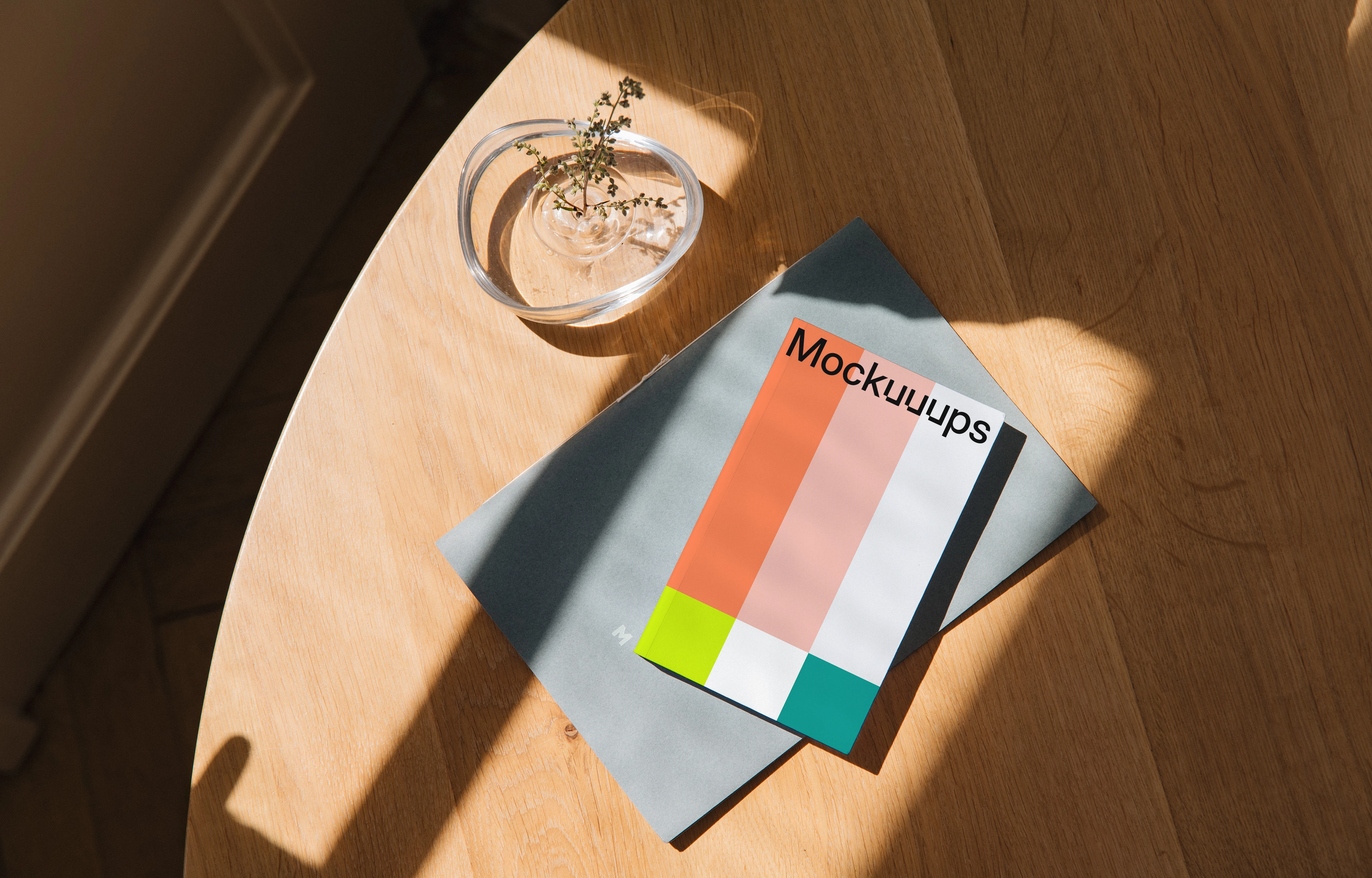 Softcover book mockup on a wooden table with sunlight