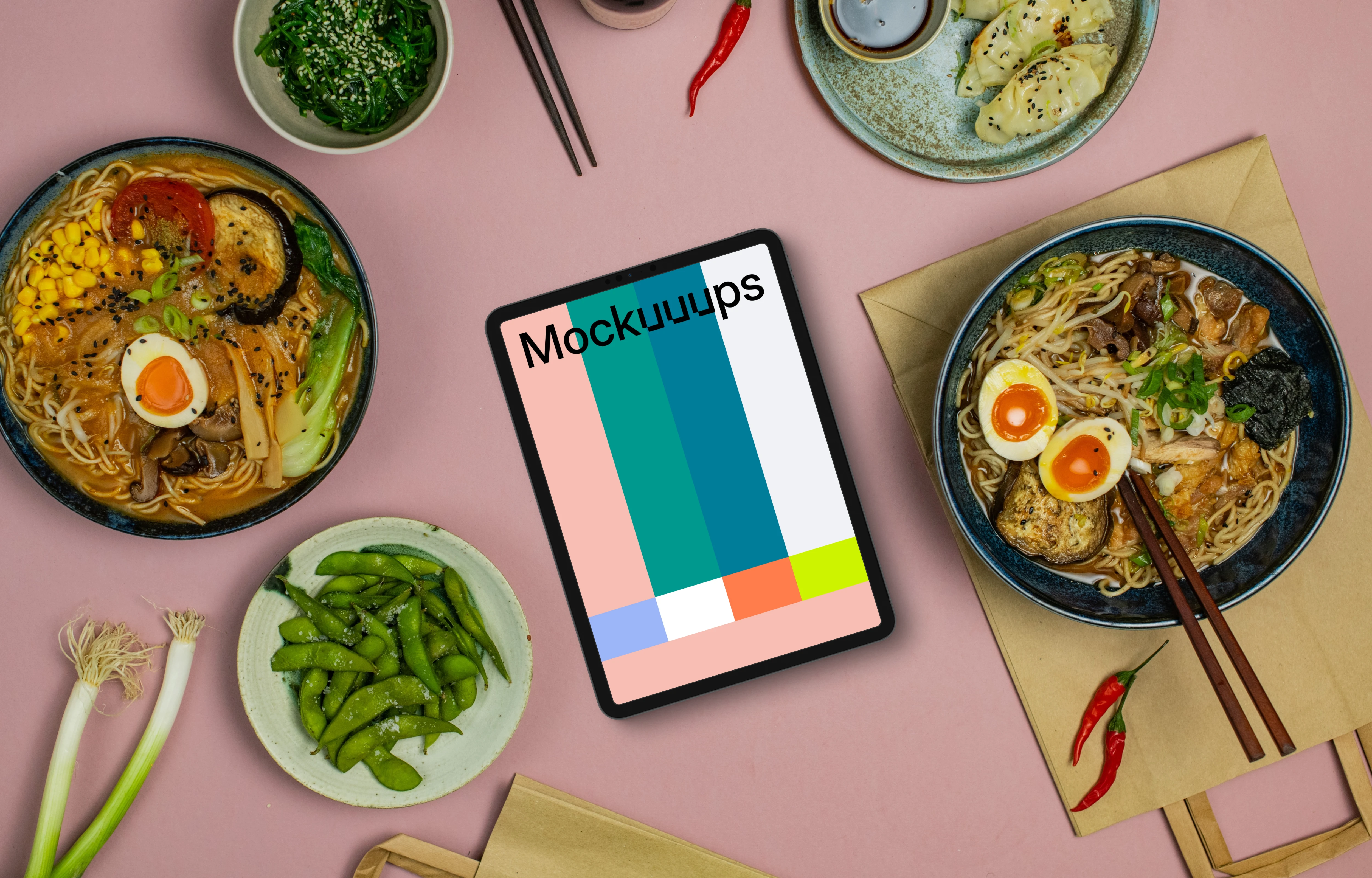 Tablet mockup between ramen bowls
