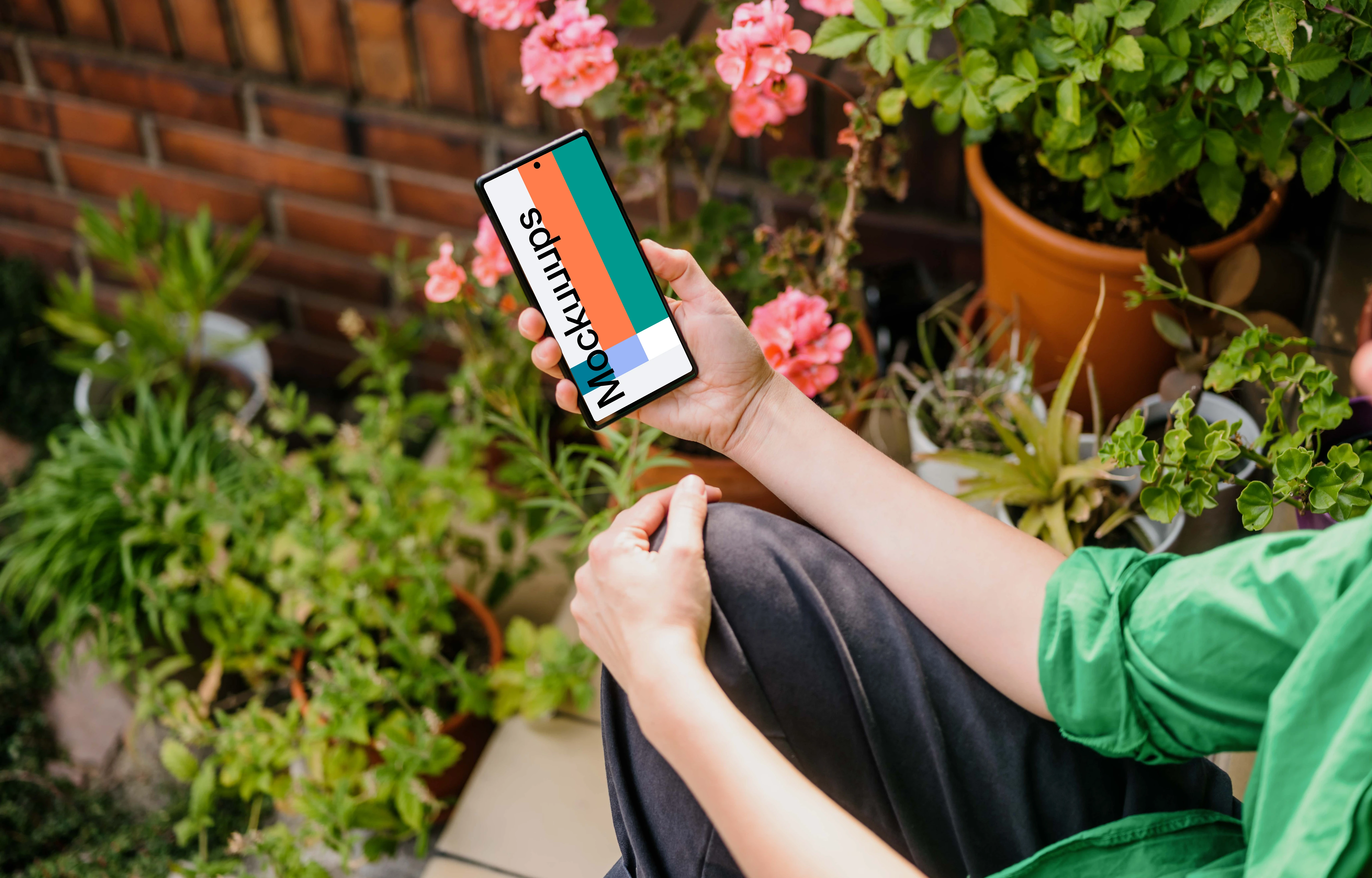 Woman sitting in a garden and holding a Google Pixel mockup