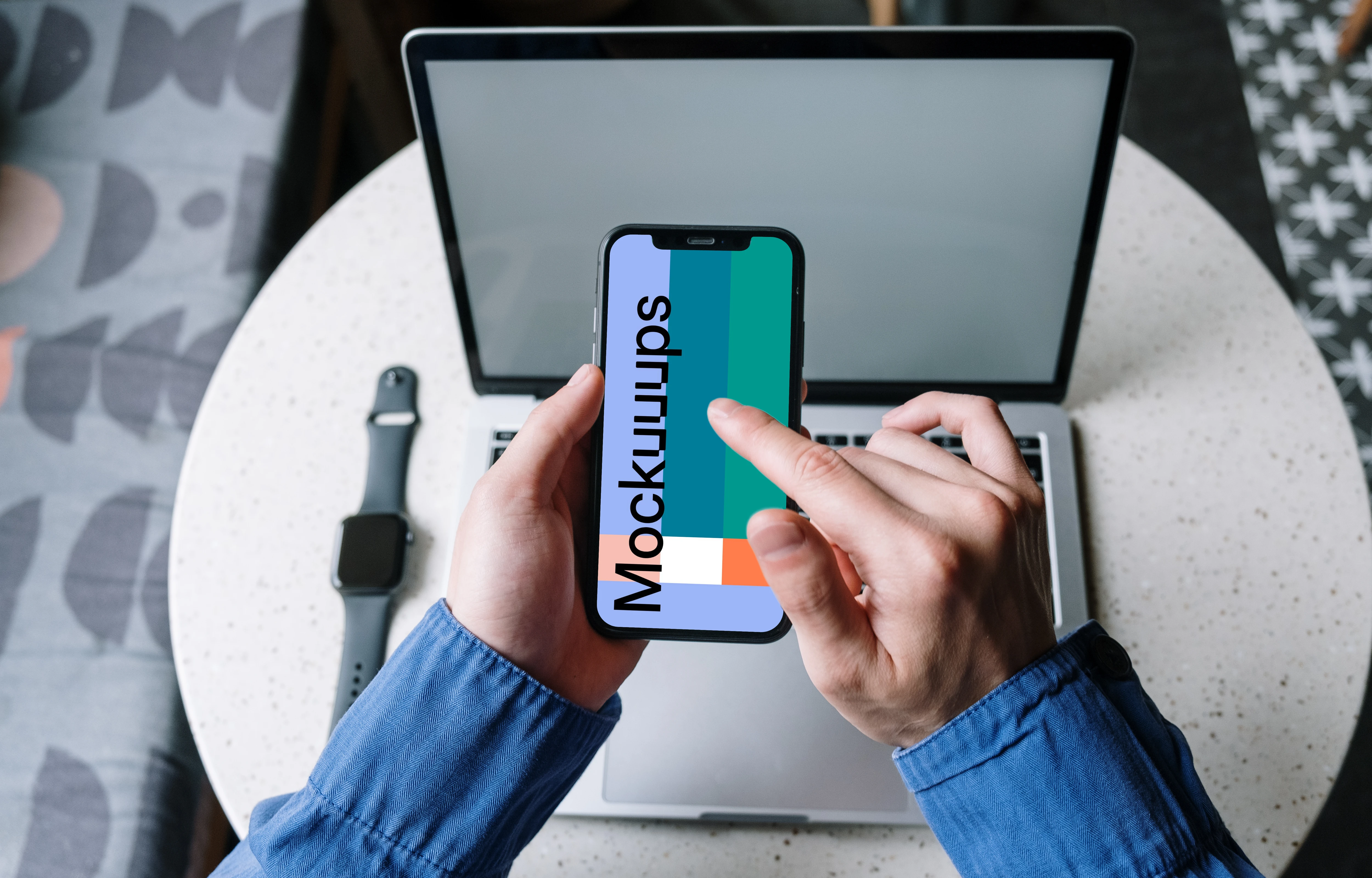User in blue shirt typing on an iPhone 12 mockup