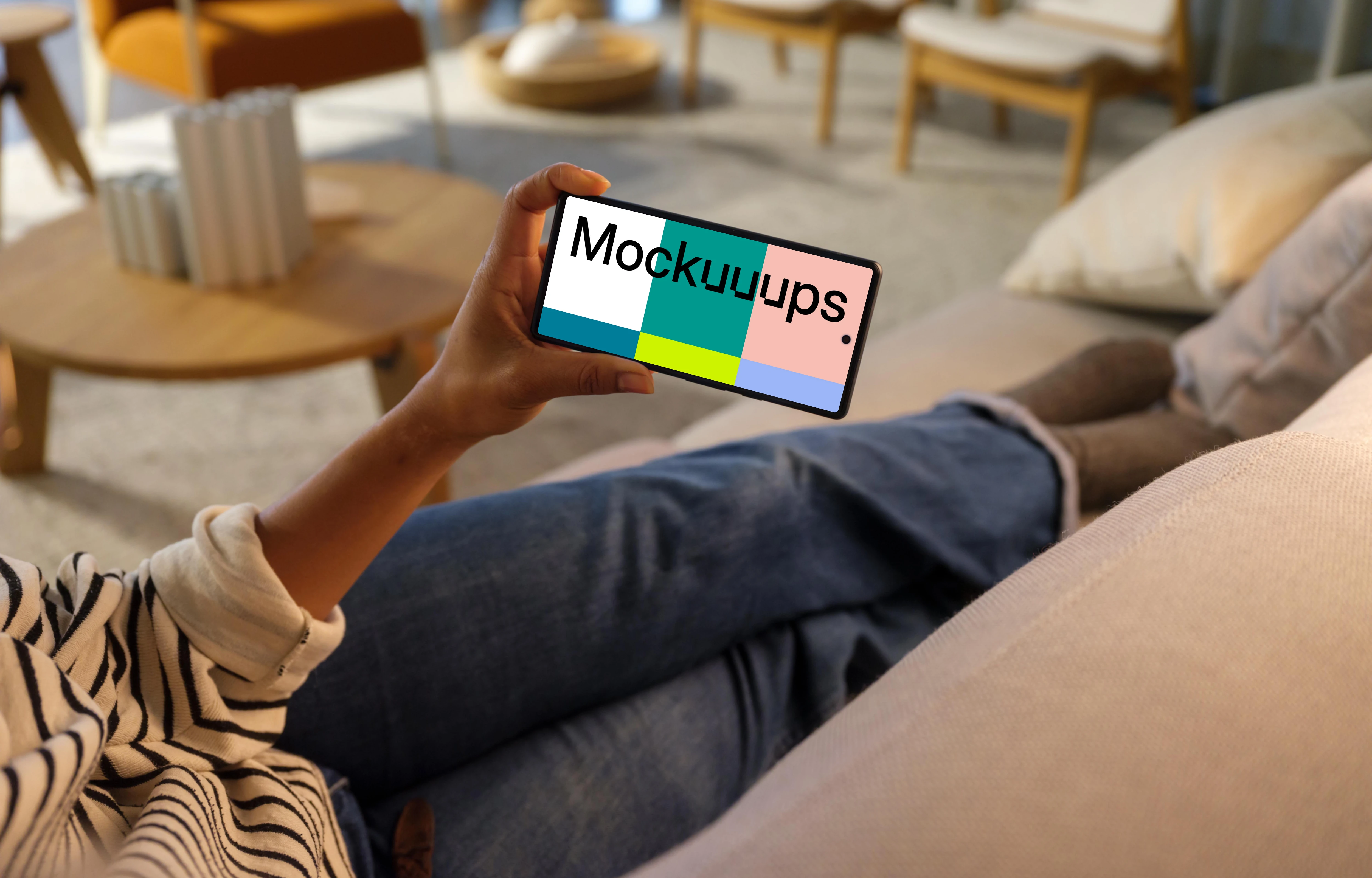 Woman hand holding a phone while laying on a couch