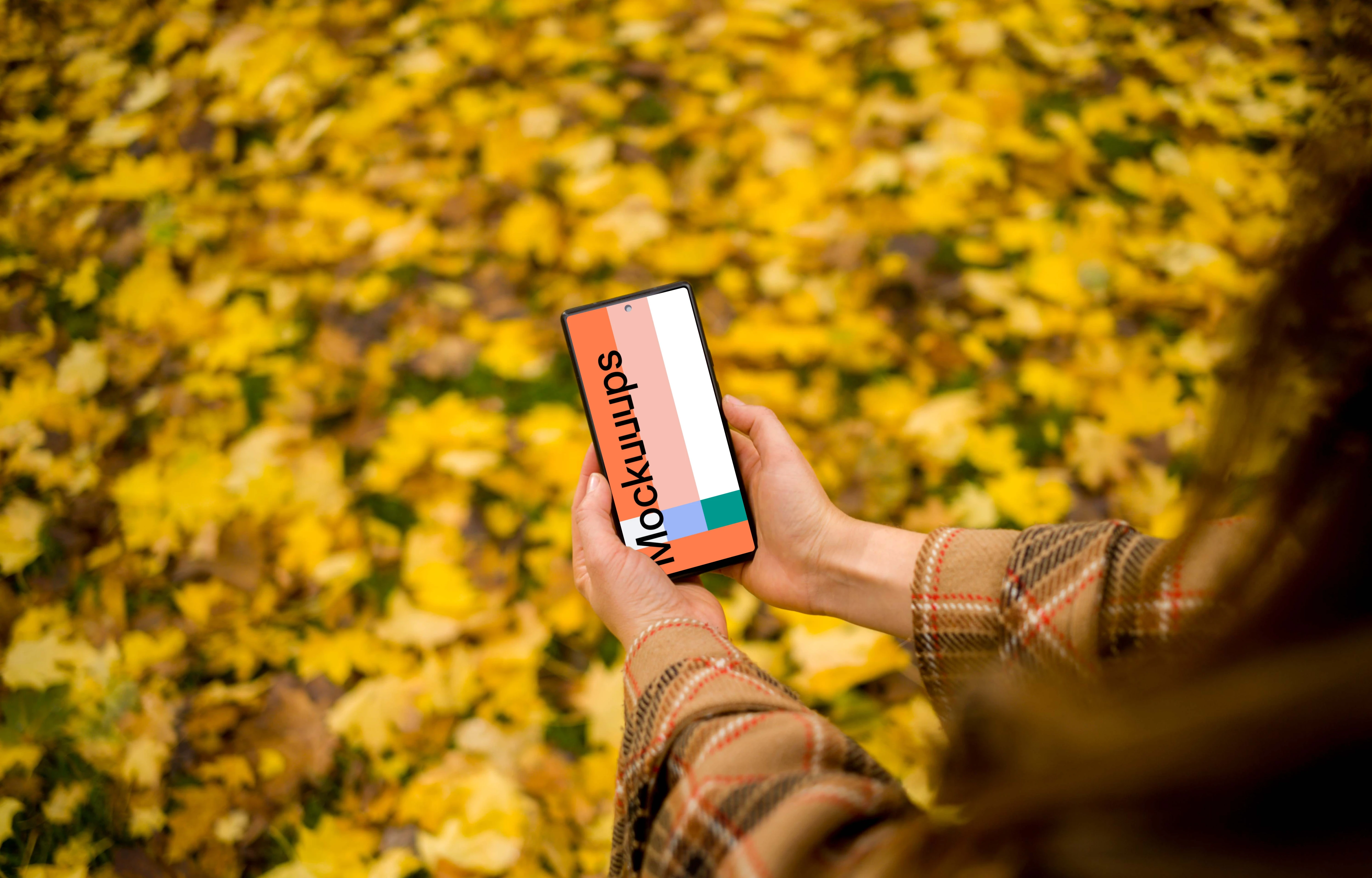 Female holding a phone mockup with autumn vibe