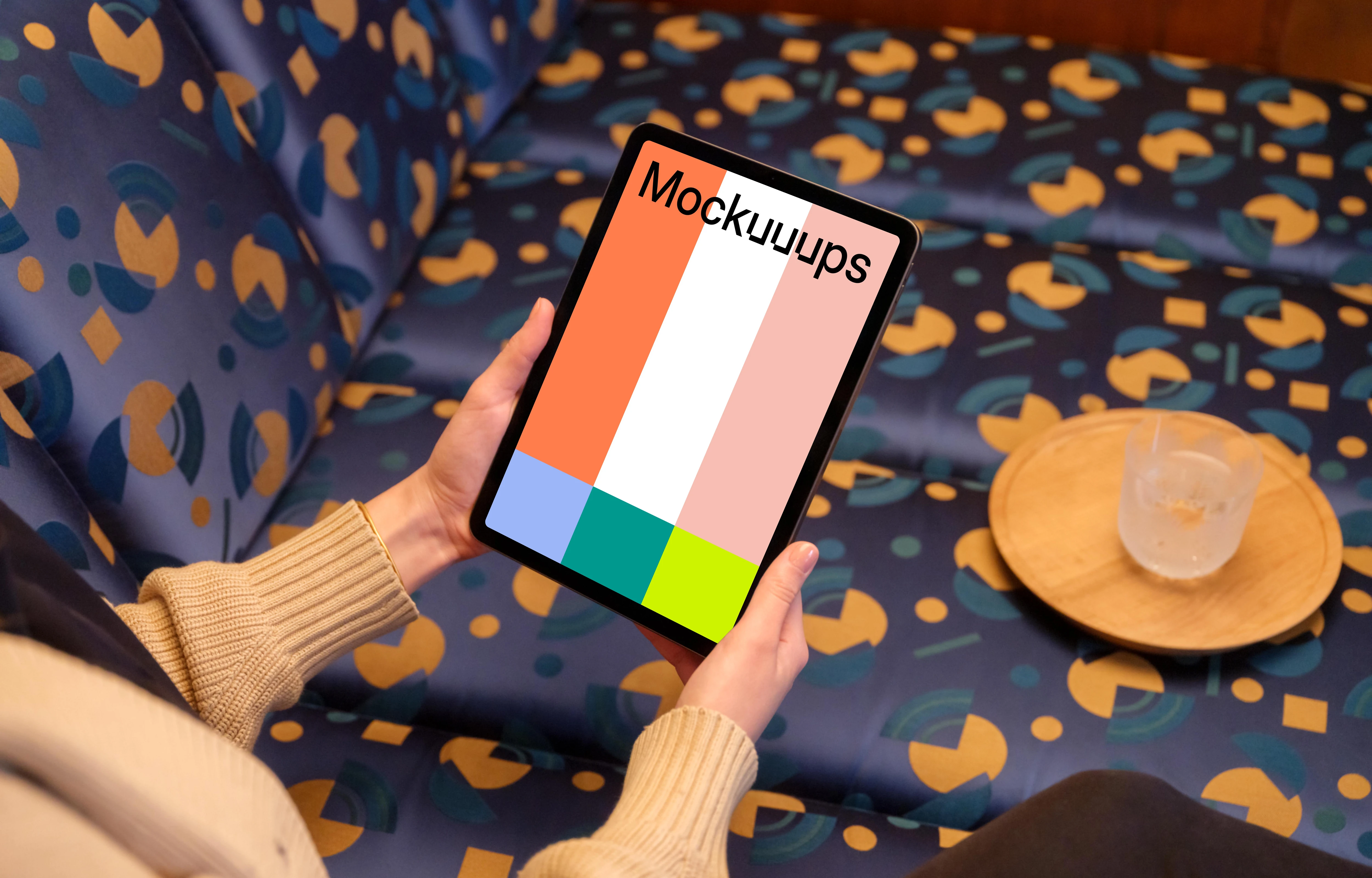 Female holding iPad mockup in colorful lounge setting