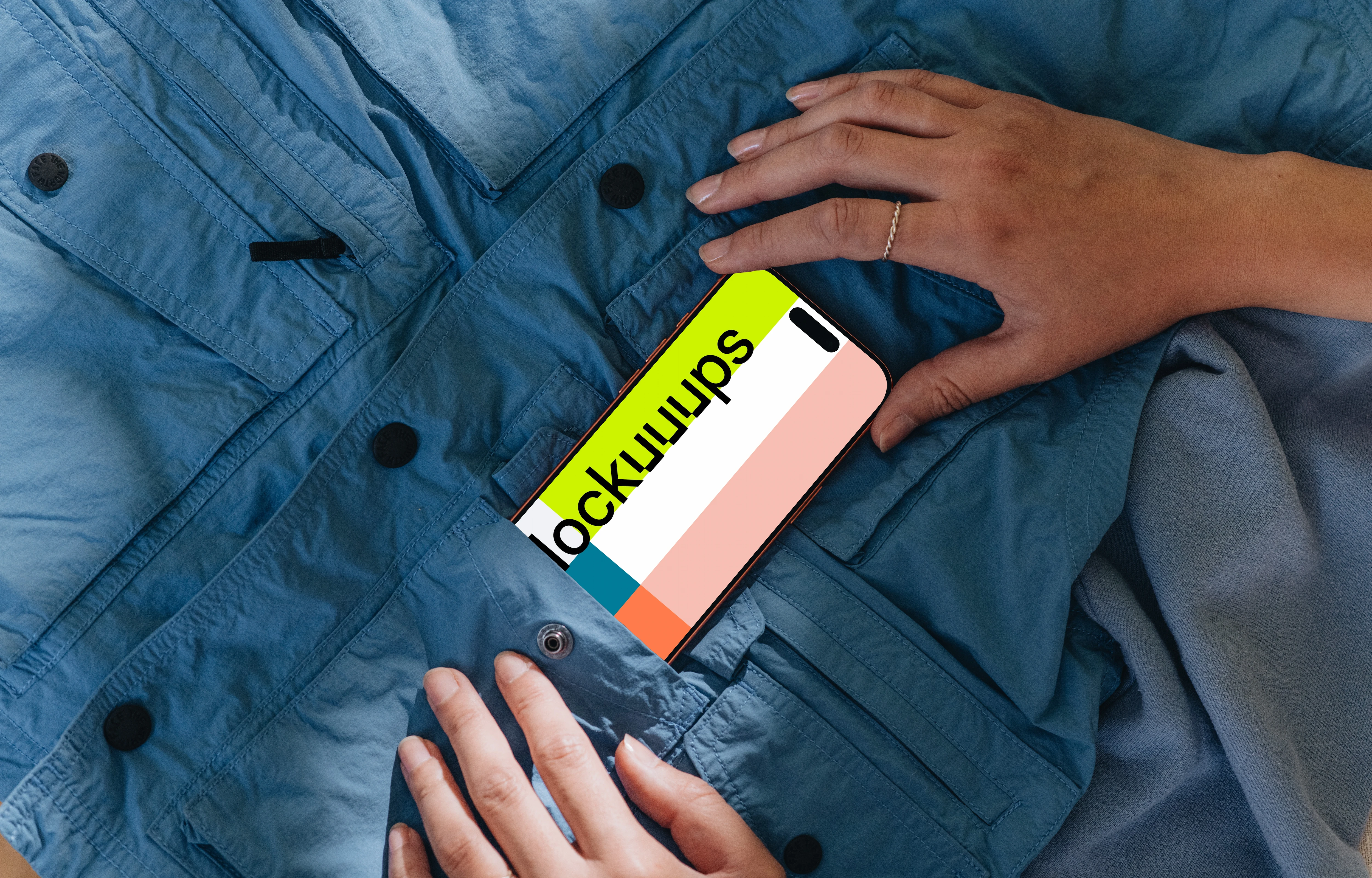 Free iPhone 17 Pro mockup with hand on blue jacket