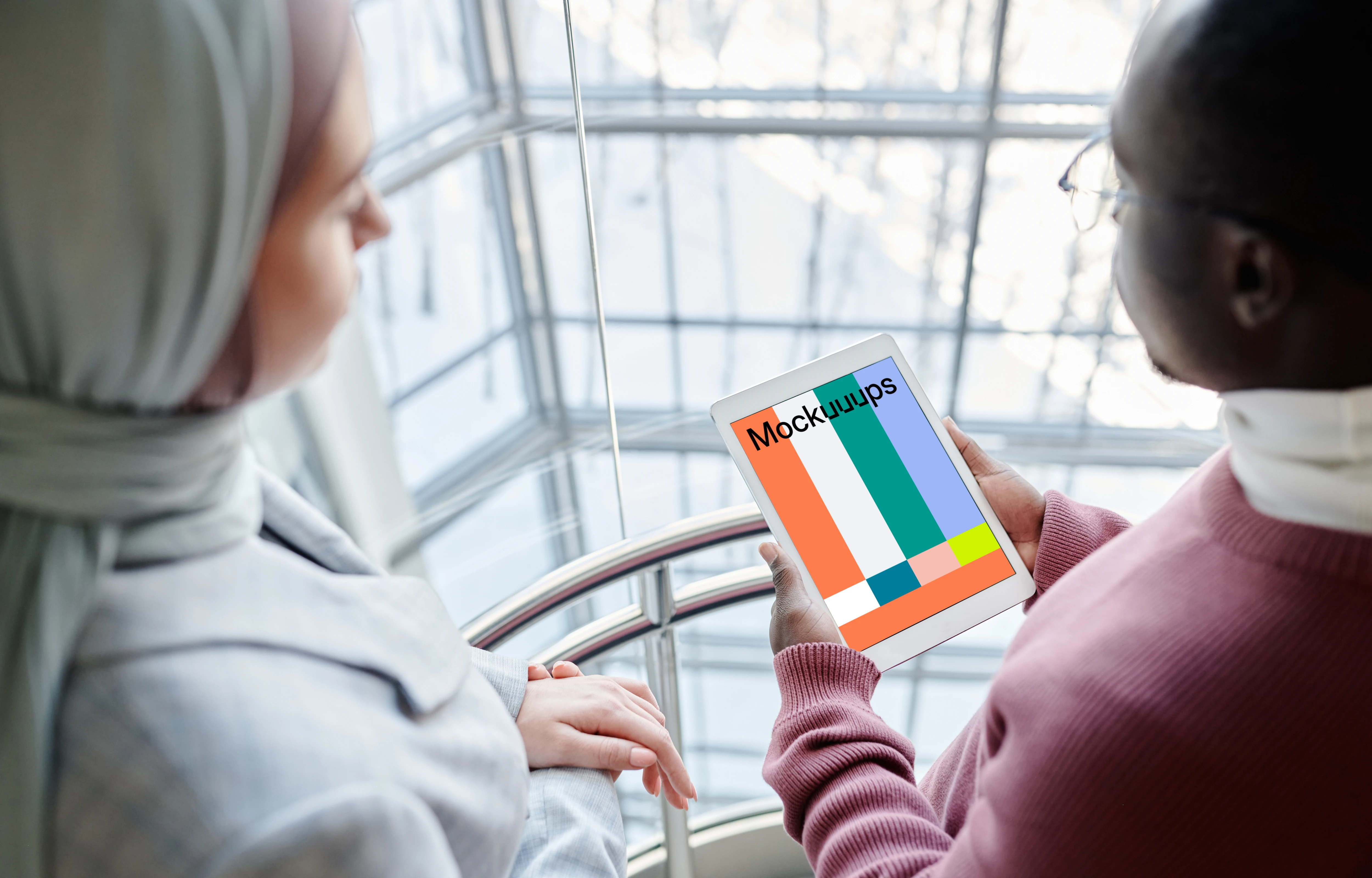 iPad Mini mockup held by a user in with a lady beside him