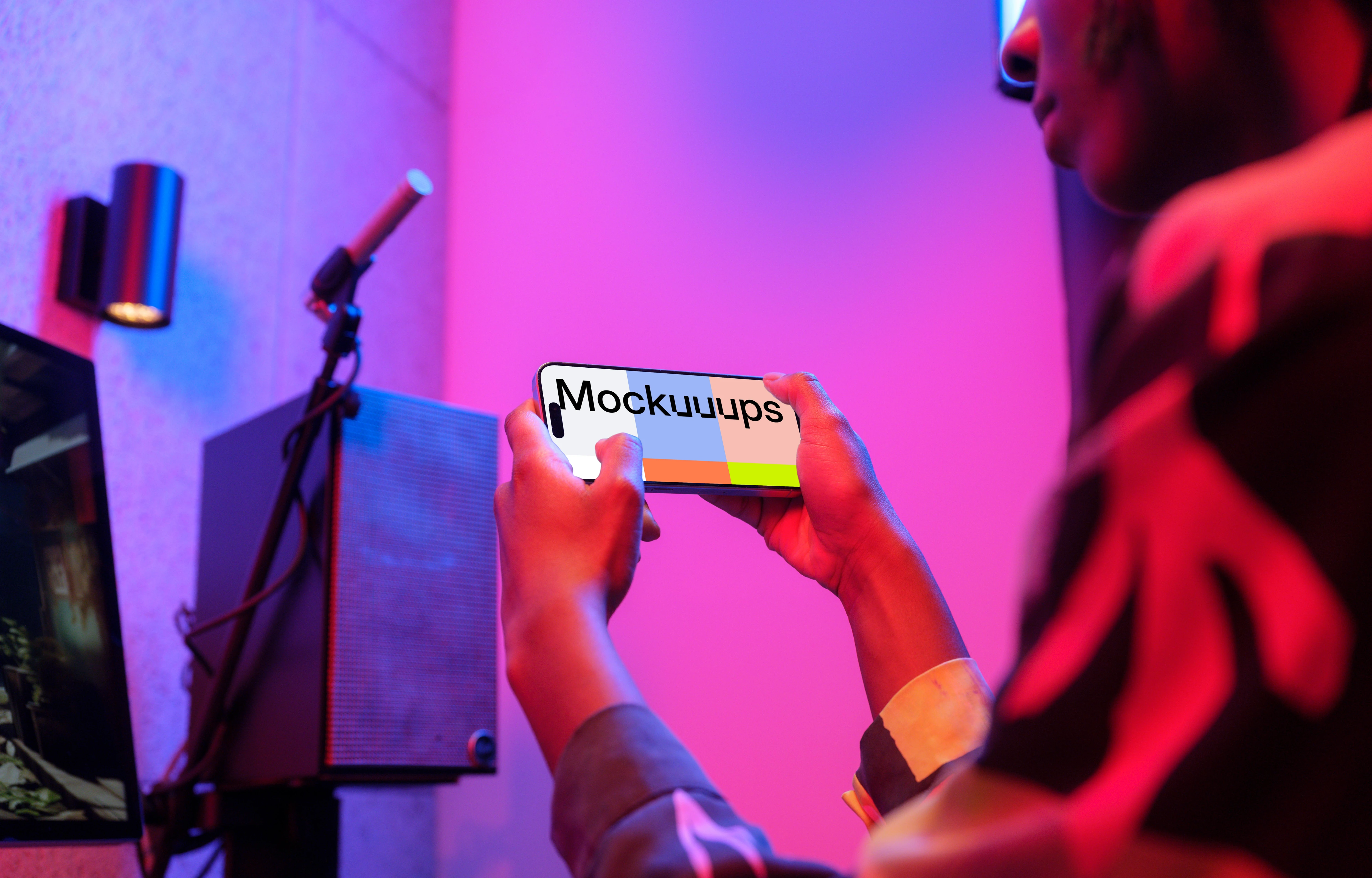 iPhone 15 Pro mockup in gamer's hands with dynamic lighting