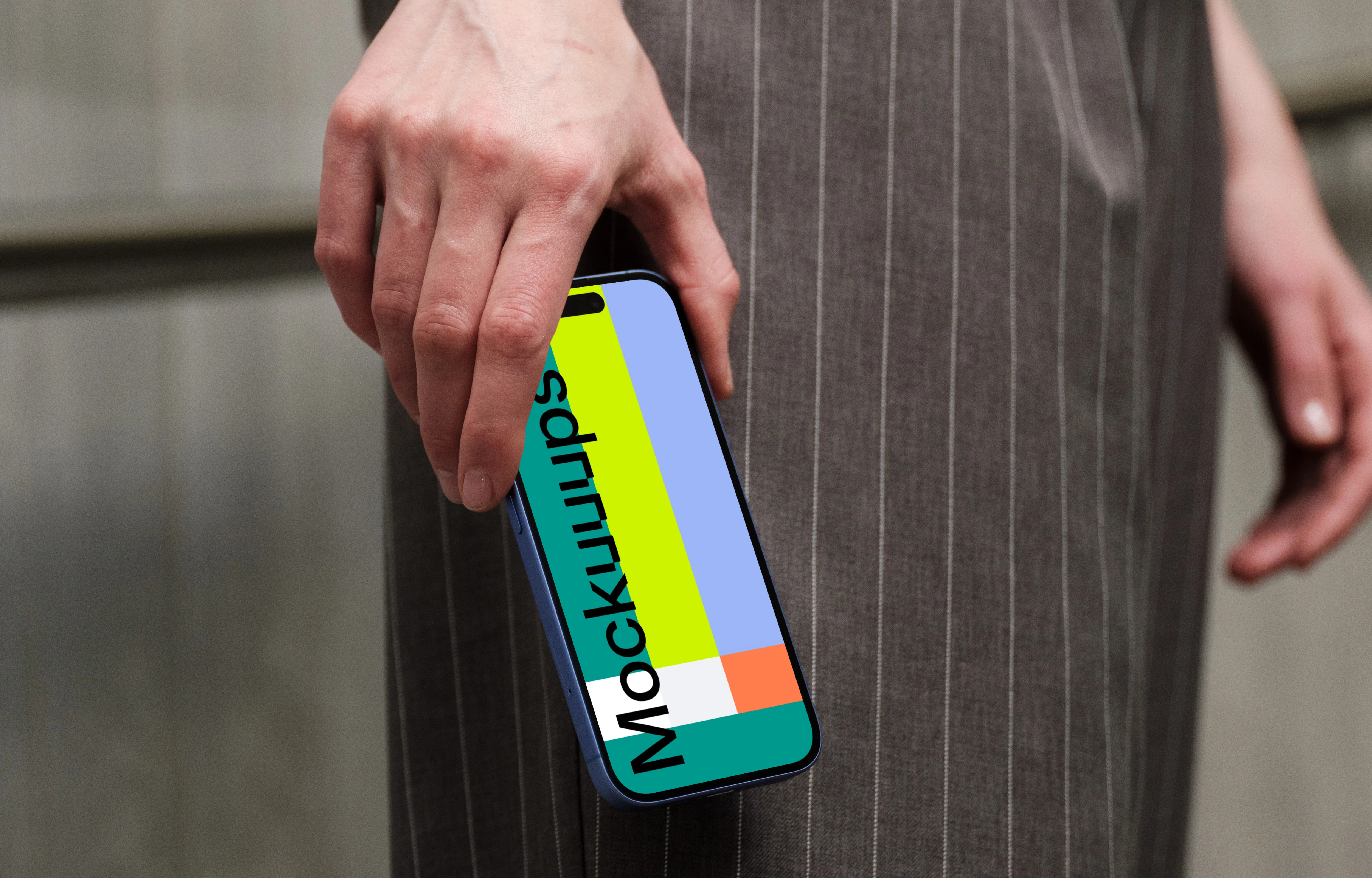 iPhone 16 mockup in hand with pinstripe pants