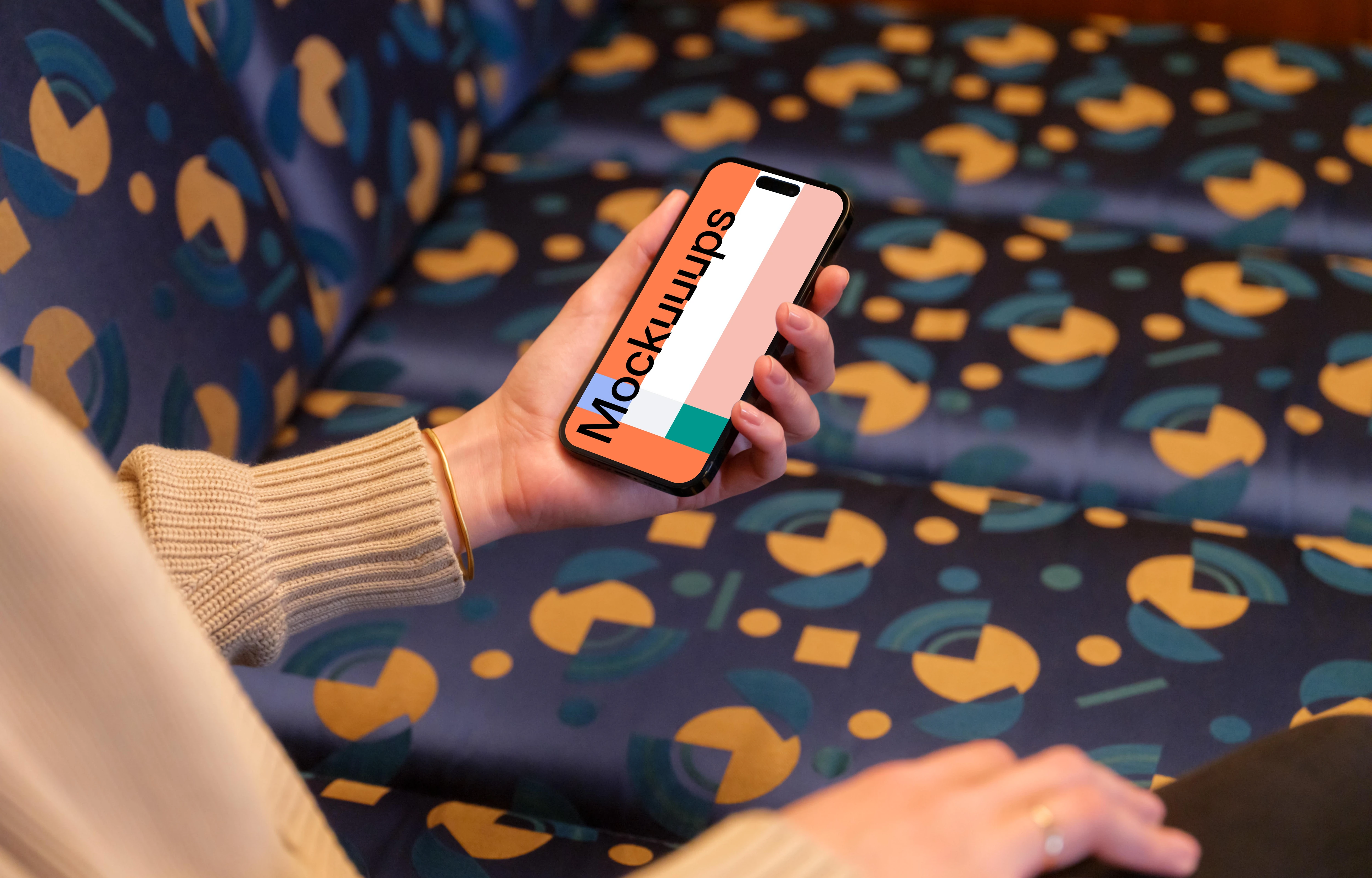 iPhone mockup held by woman’s hand in the lounge 