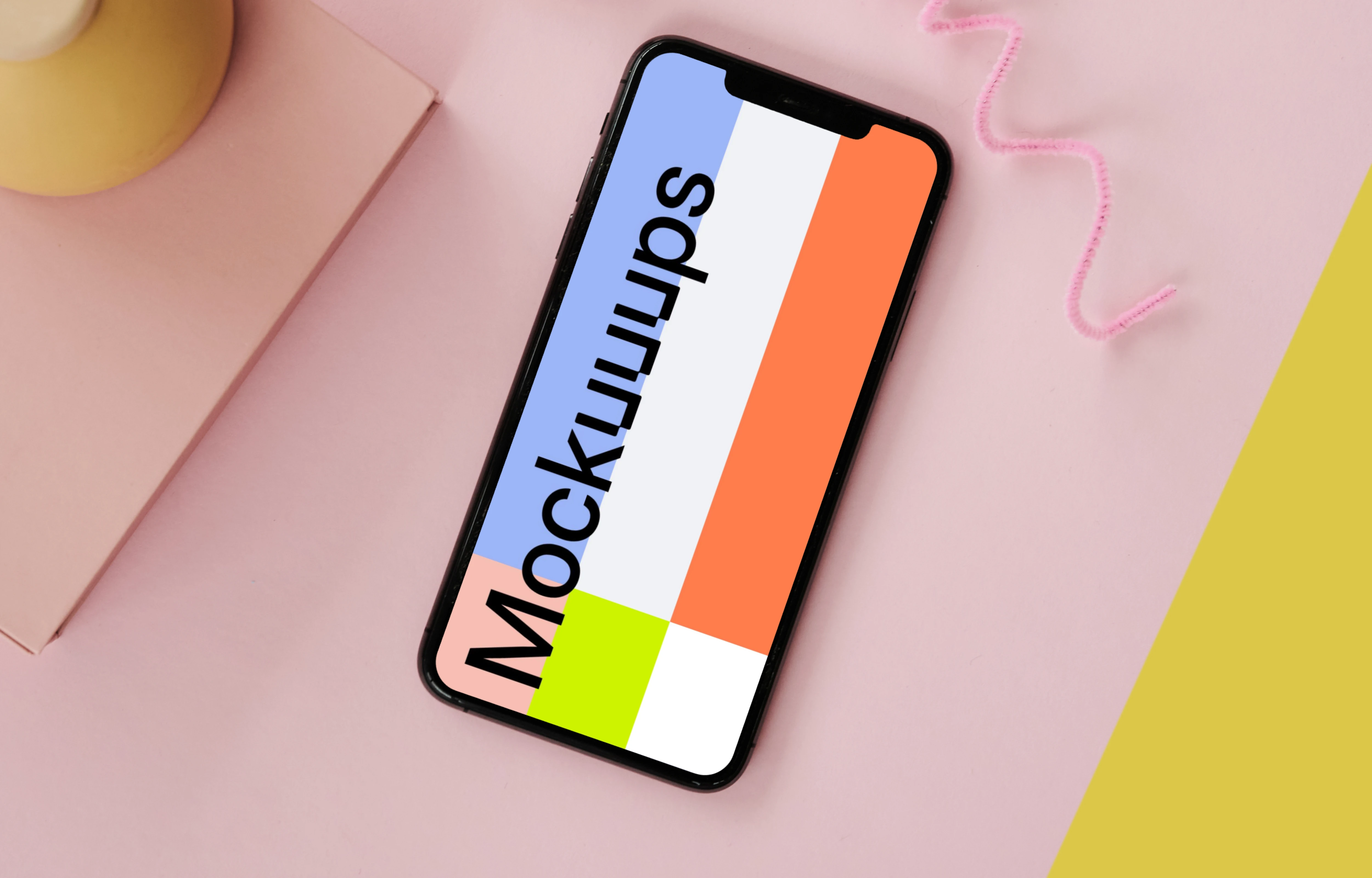 iPhone mockup on a pink table