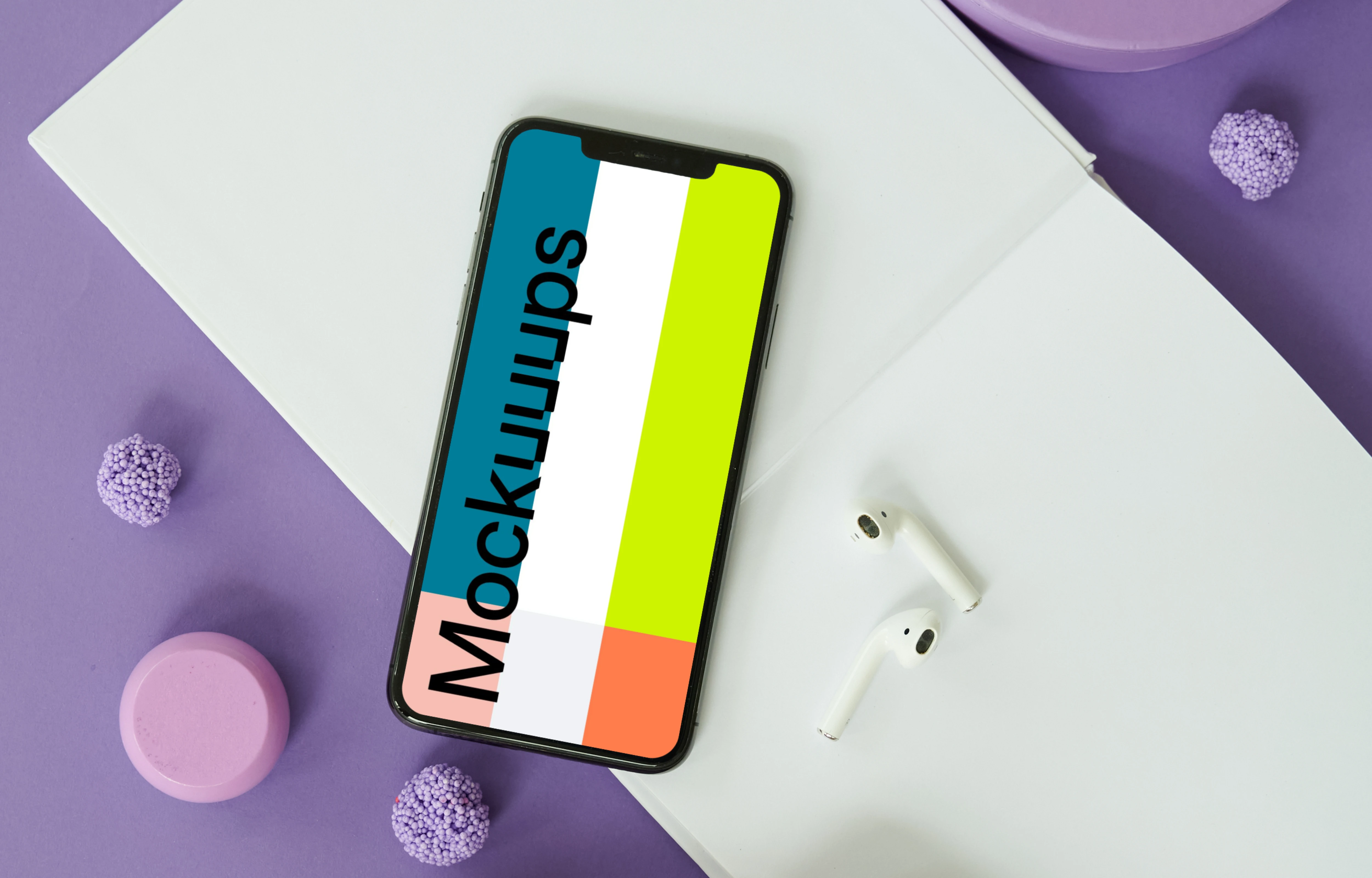 iPhone mockup on a table with a pair of AirPods at the side