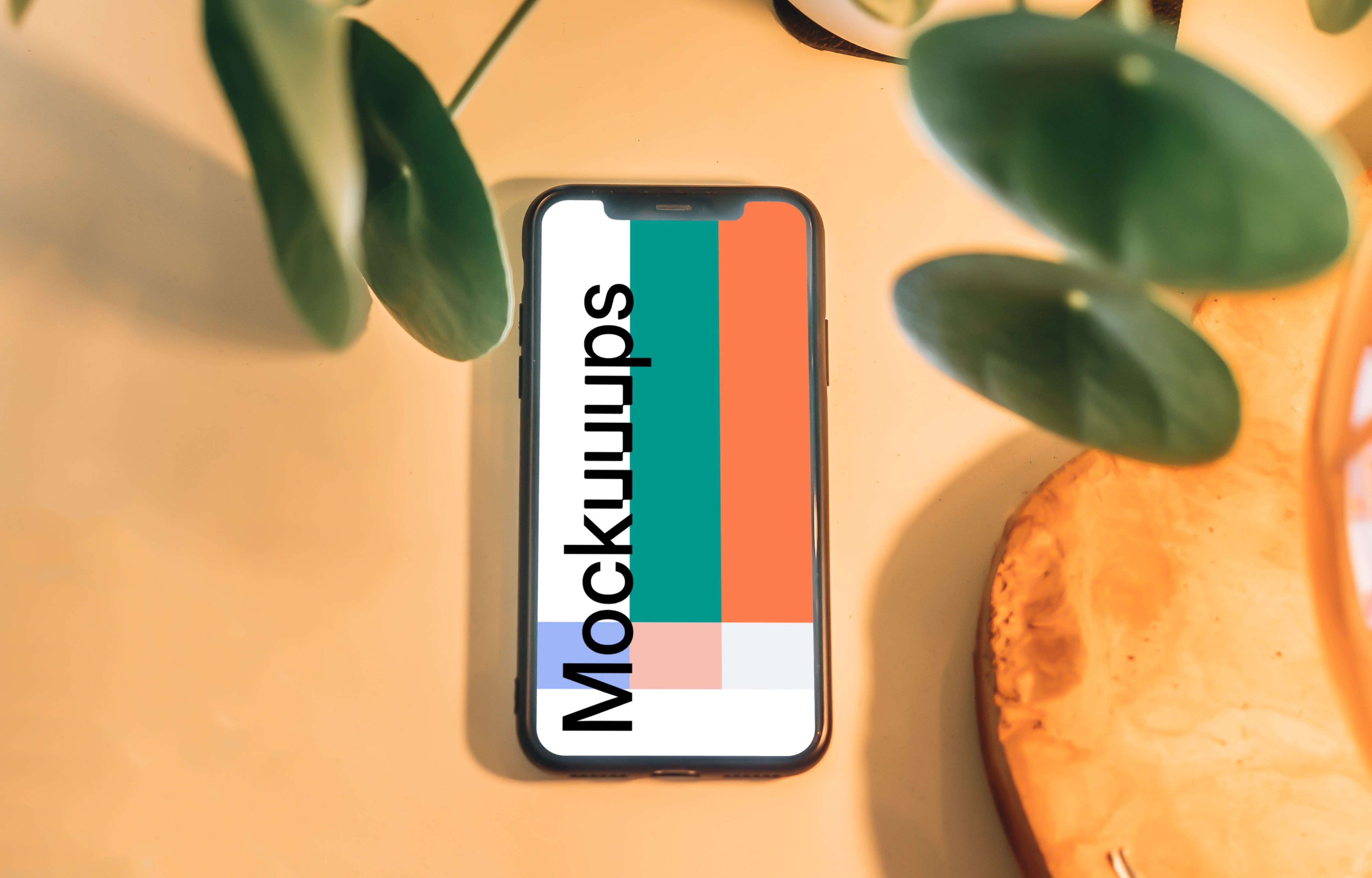 iPhone mockup underneath with leaves in foreground