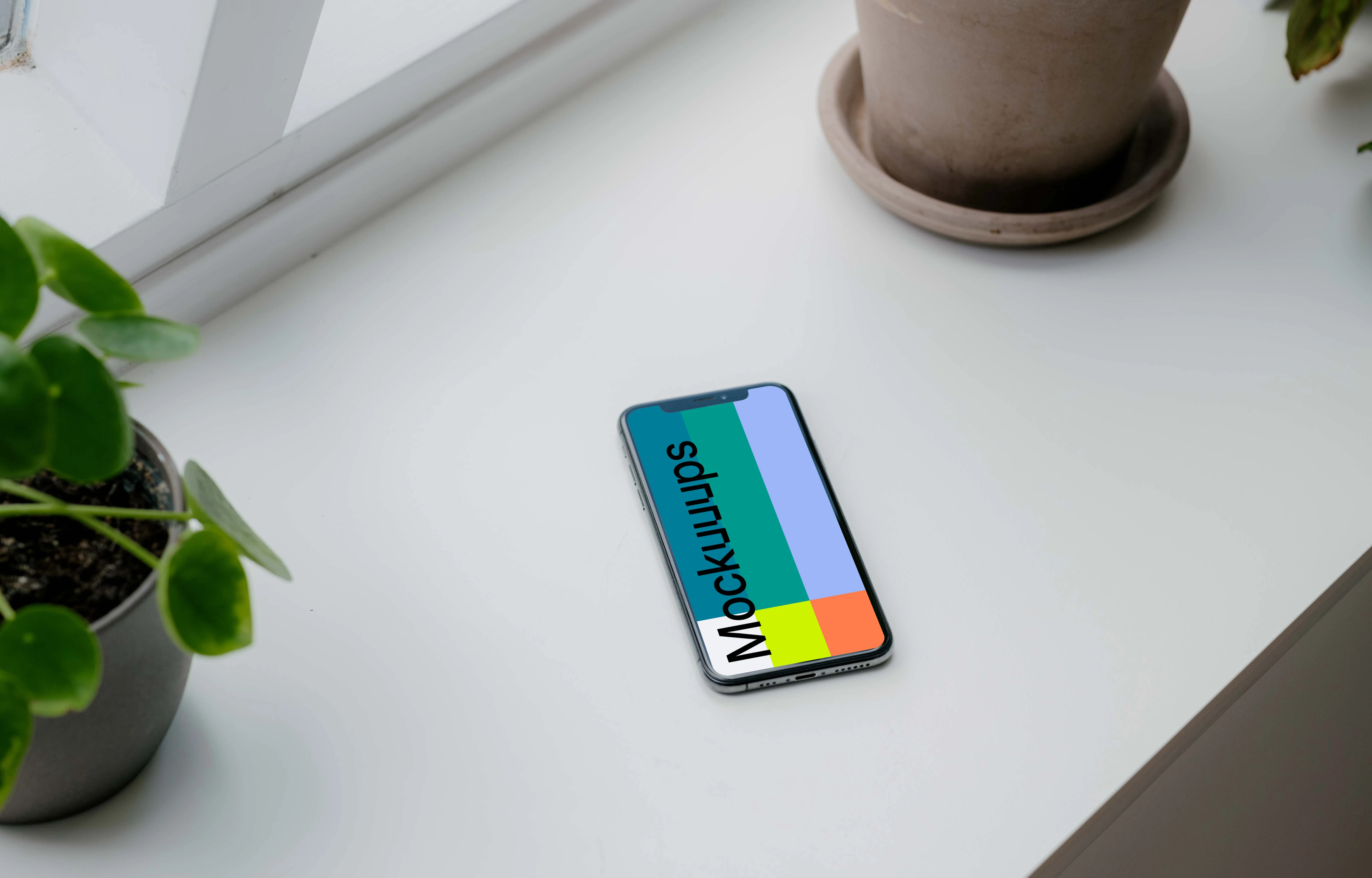 iPhone XS mockup on a window sill with plants