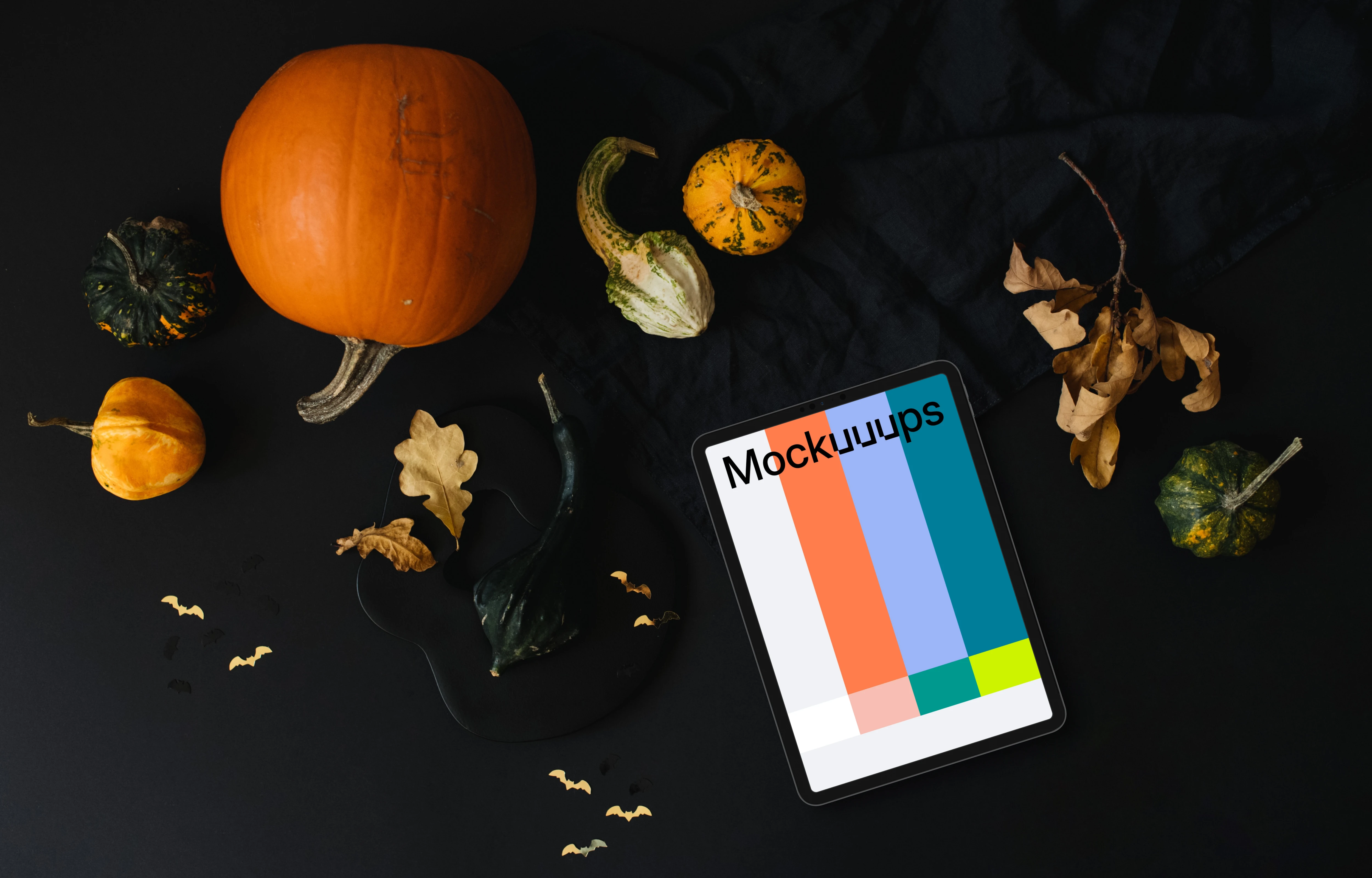 Halloween pumpkin mockup with a tablet and leaves on the side