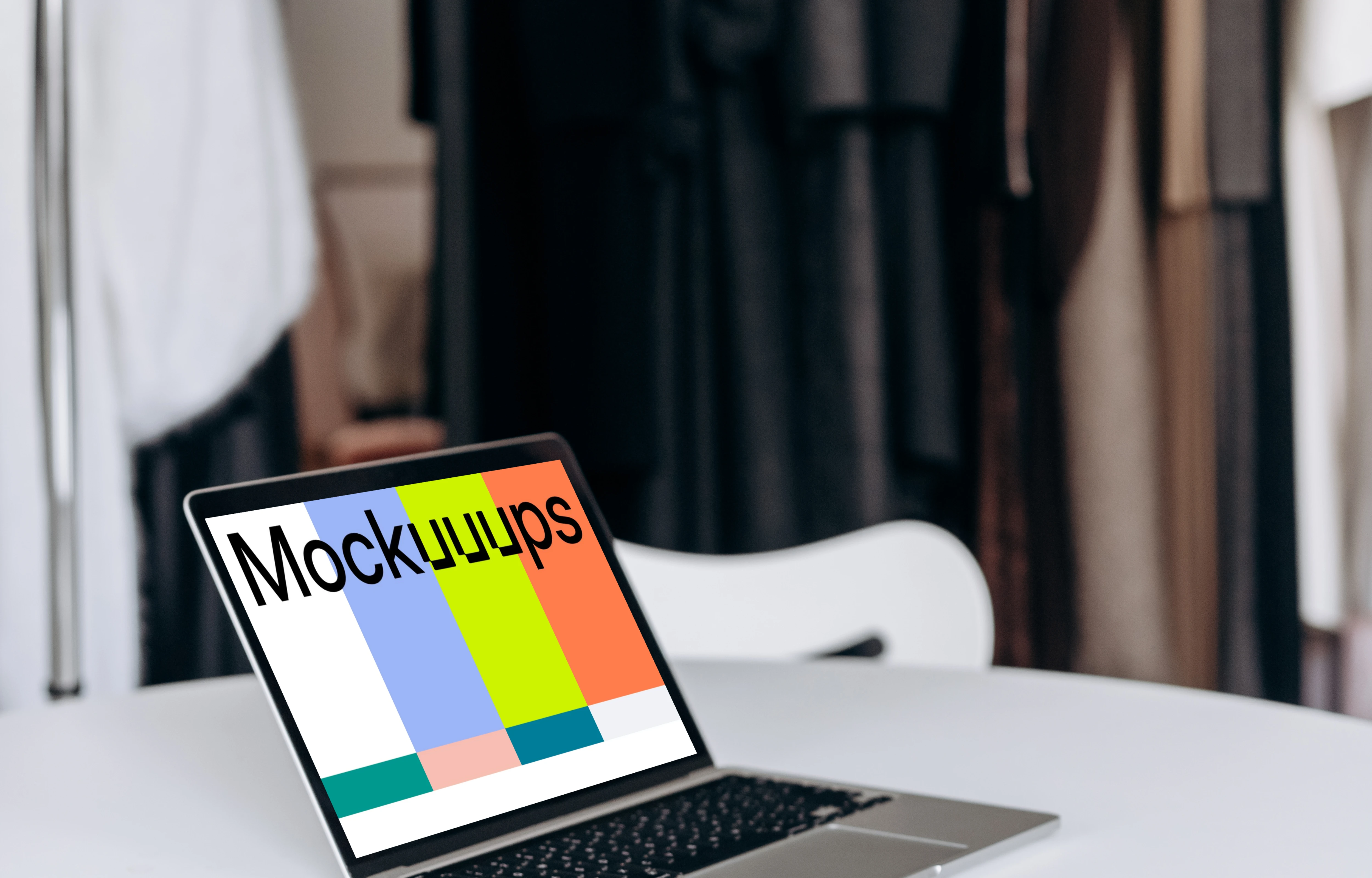 MacBook Pro mockup on a work table beside phone and notepad