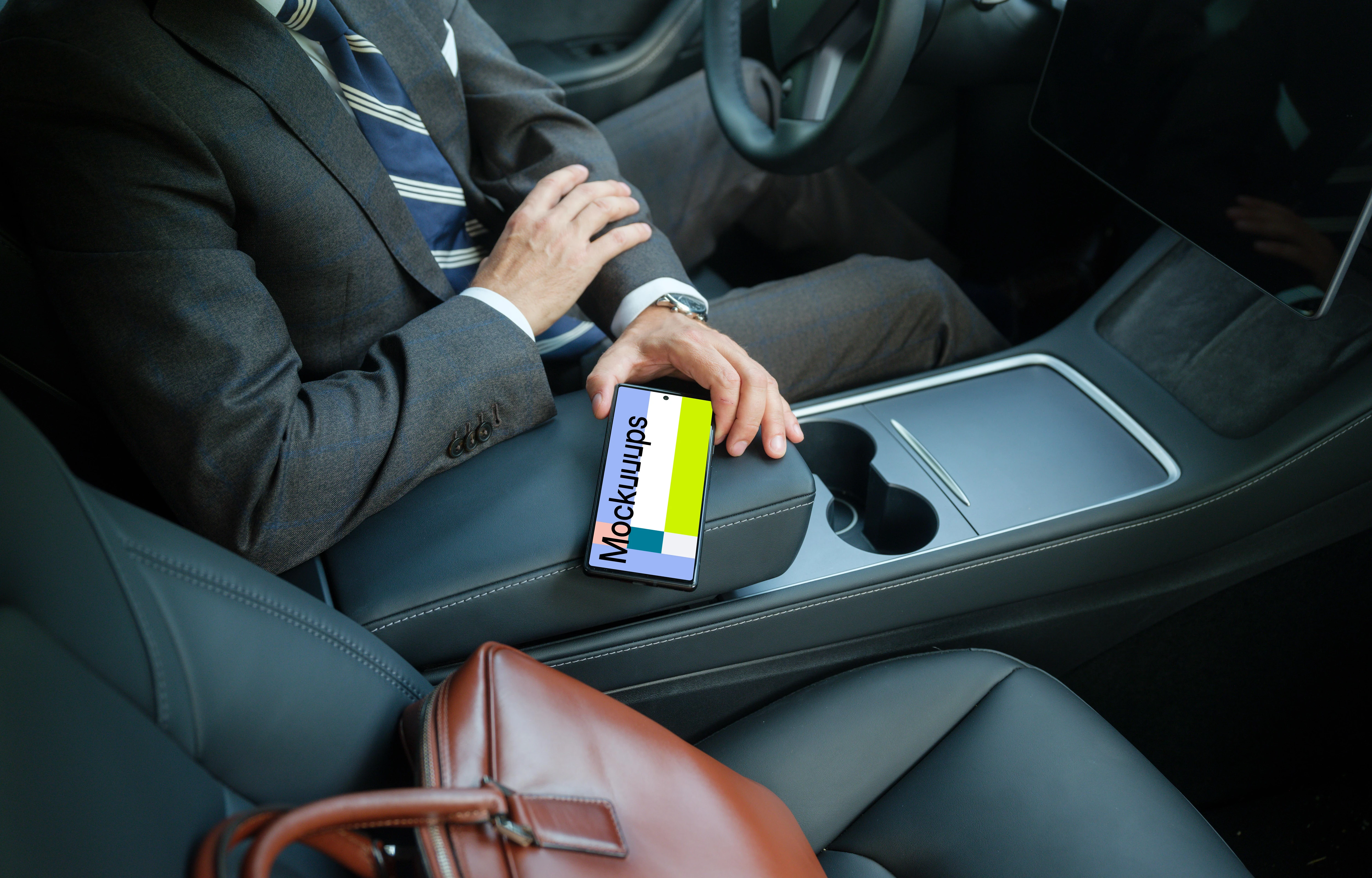 Male entrepreneur in Tesla holding a phone