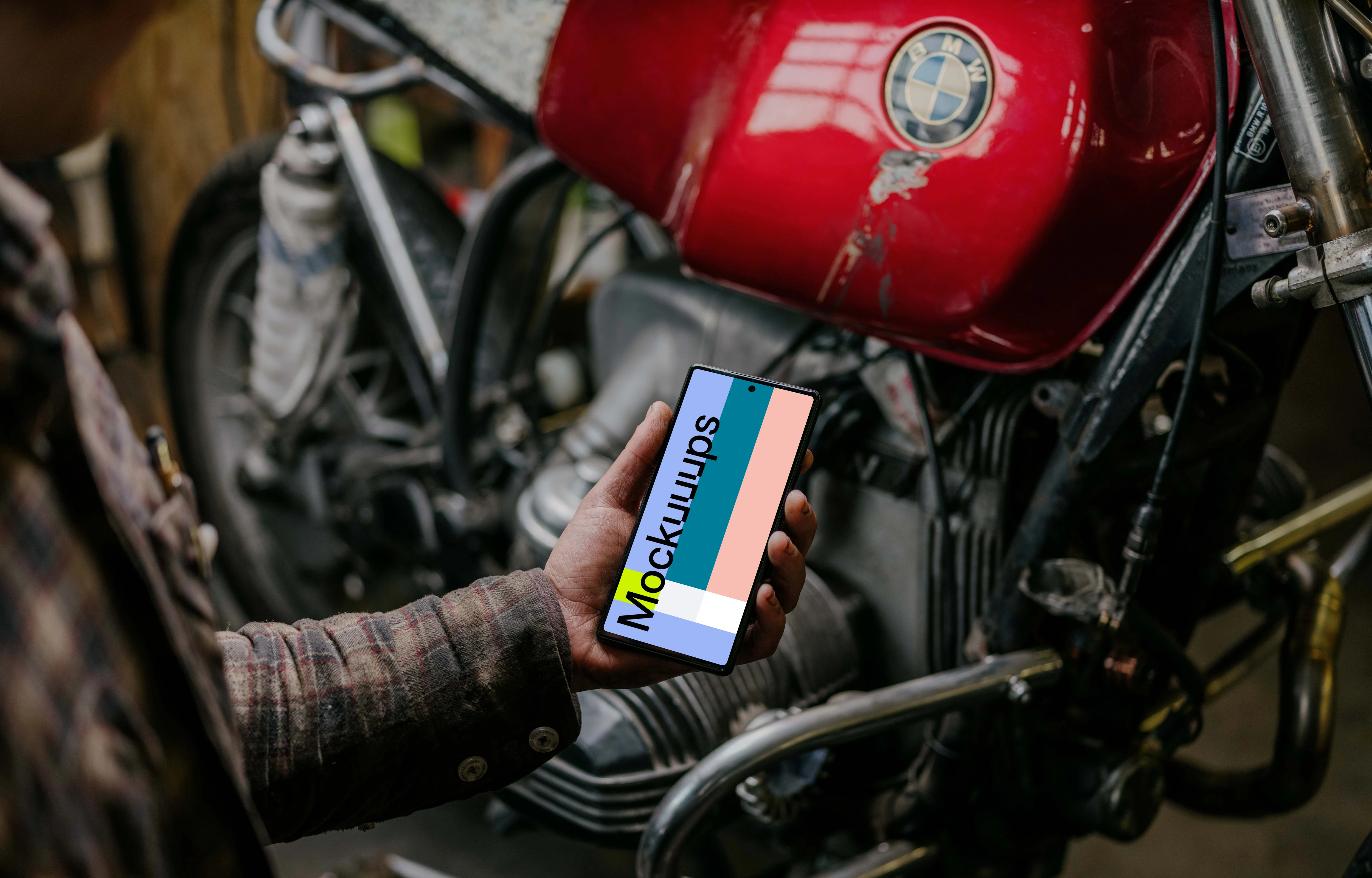 Man holding a Pixel 6 mockup beside a motorcycle