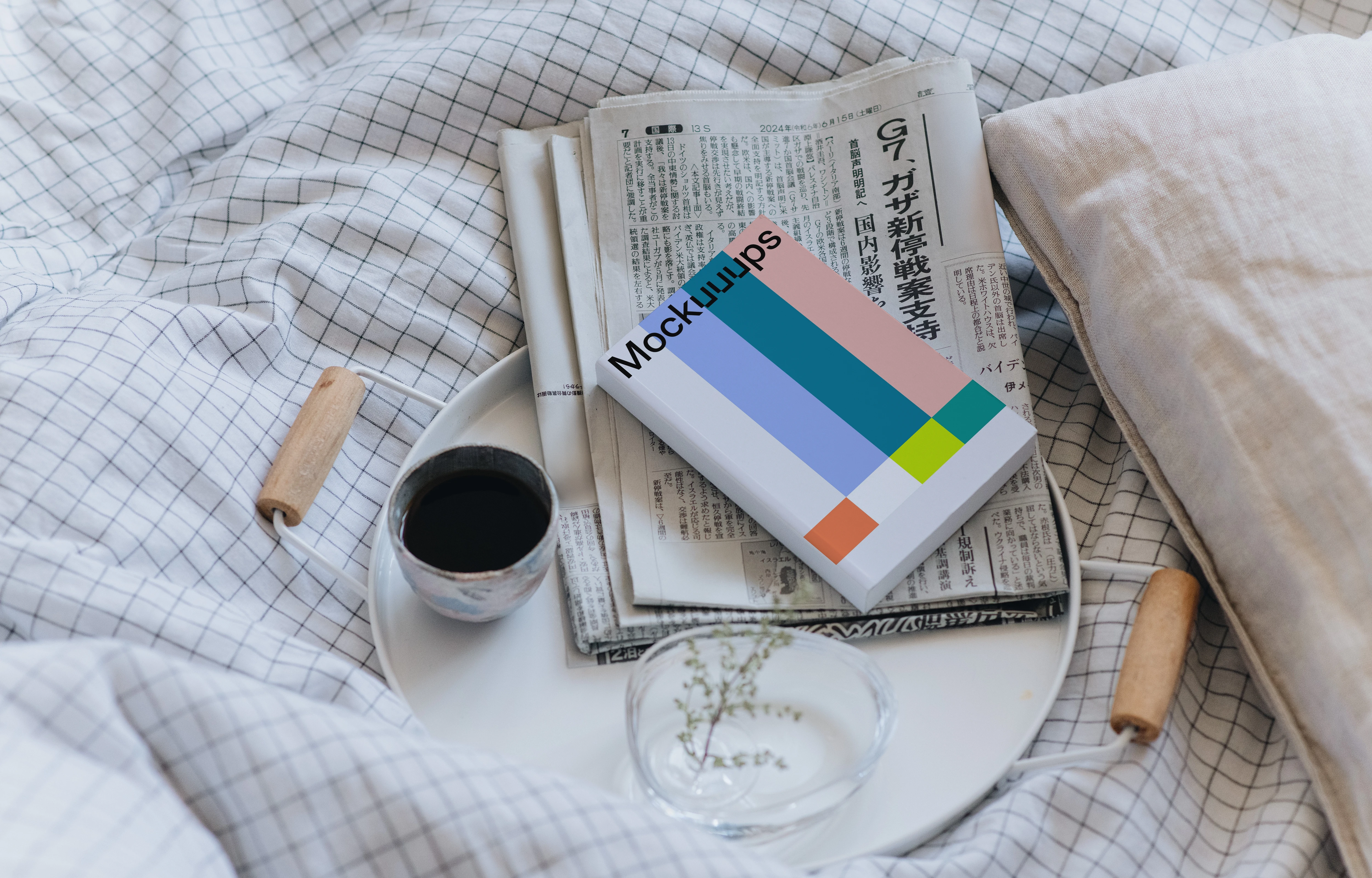 Paperback book mockup on a cozy bed with breakfast setting