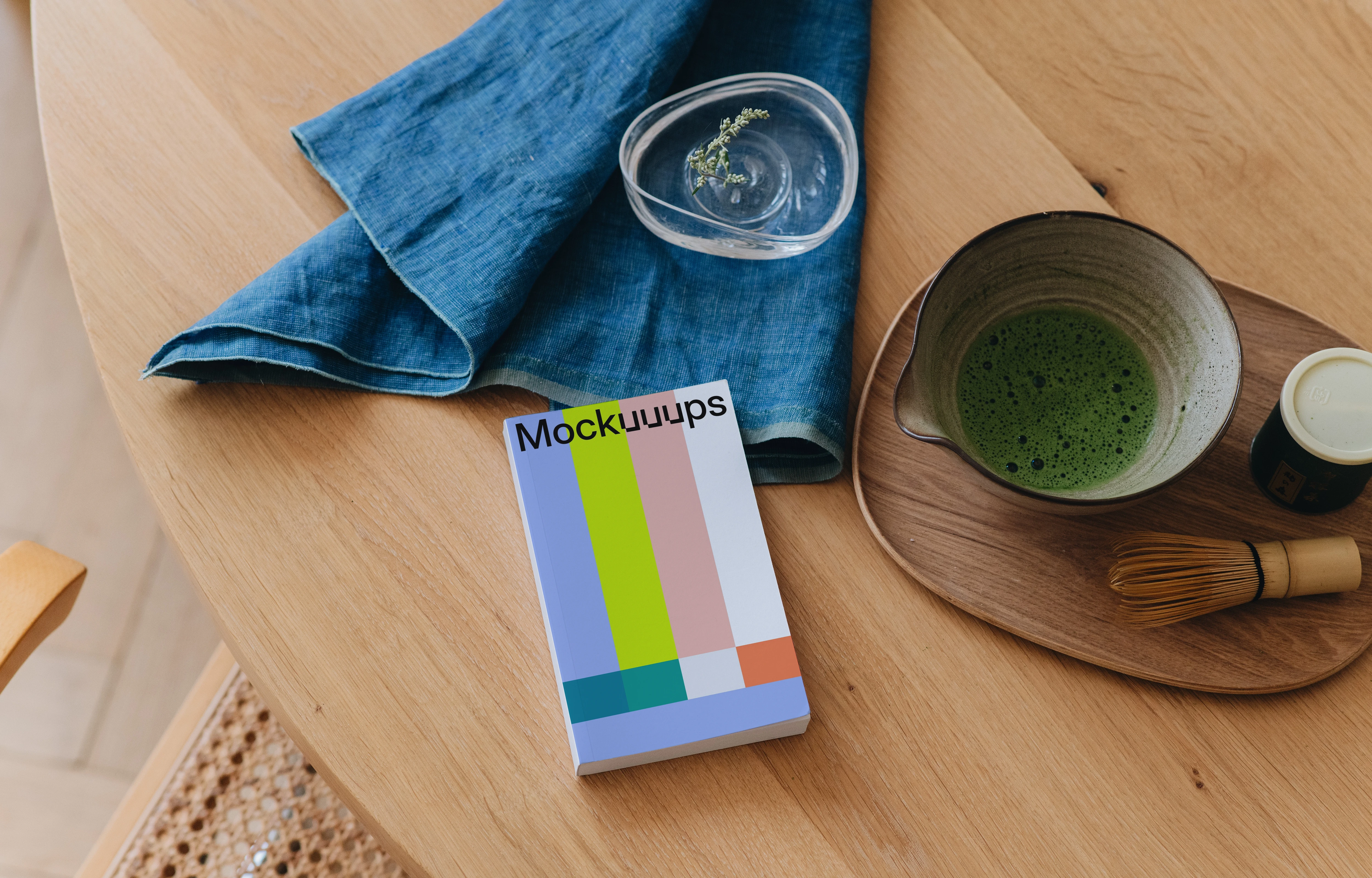 Paperback mockup on a wooden dining table with tea set