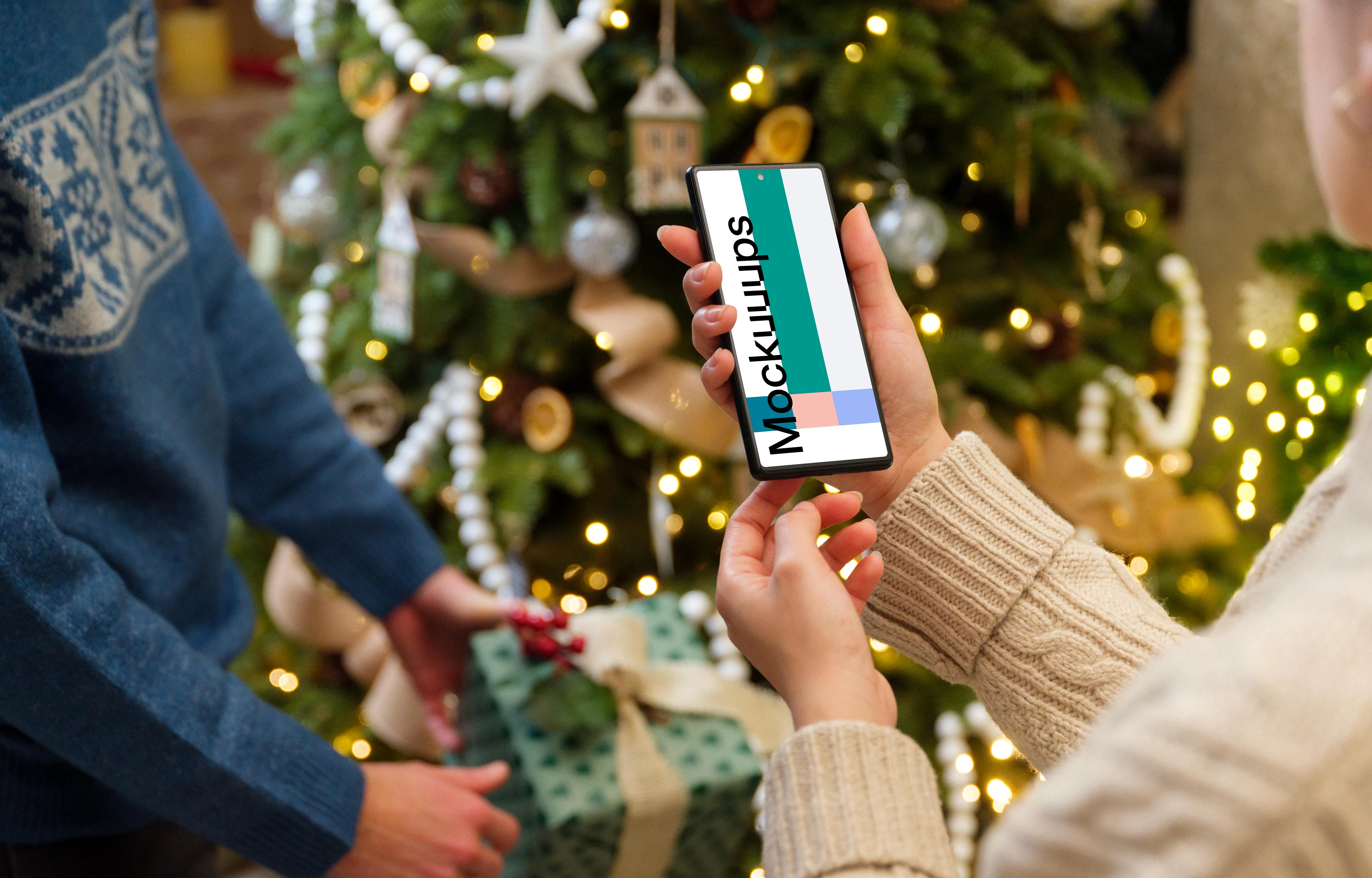 Phone mockup in hands next to the Christmas tree