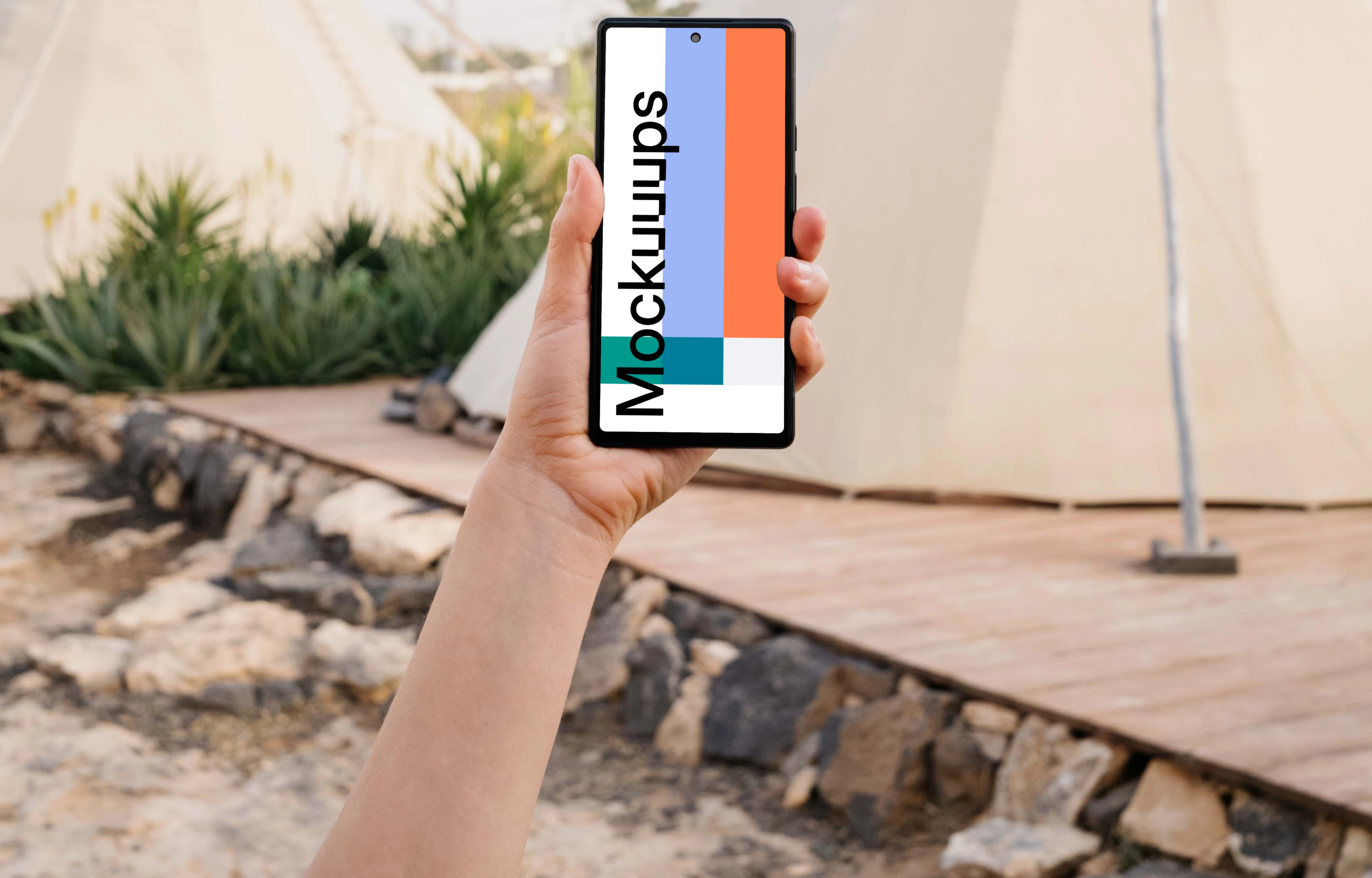 Pixel 6 mockup held by a user at an outdoor campsite