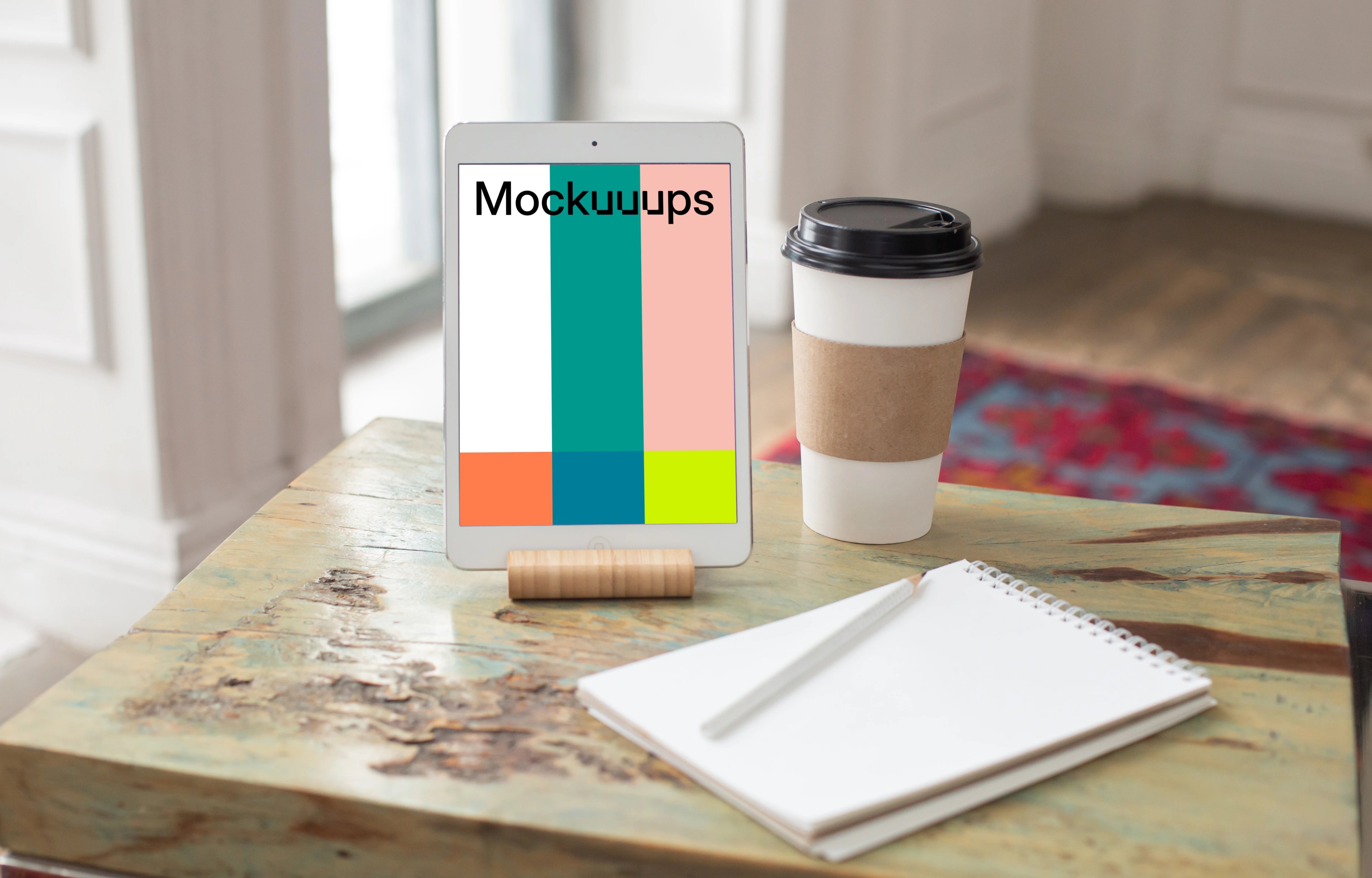  iPad Mini mockup beside a cup of coffee and a notepad