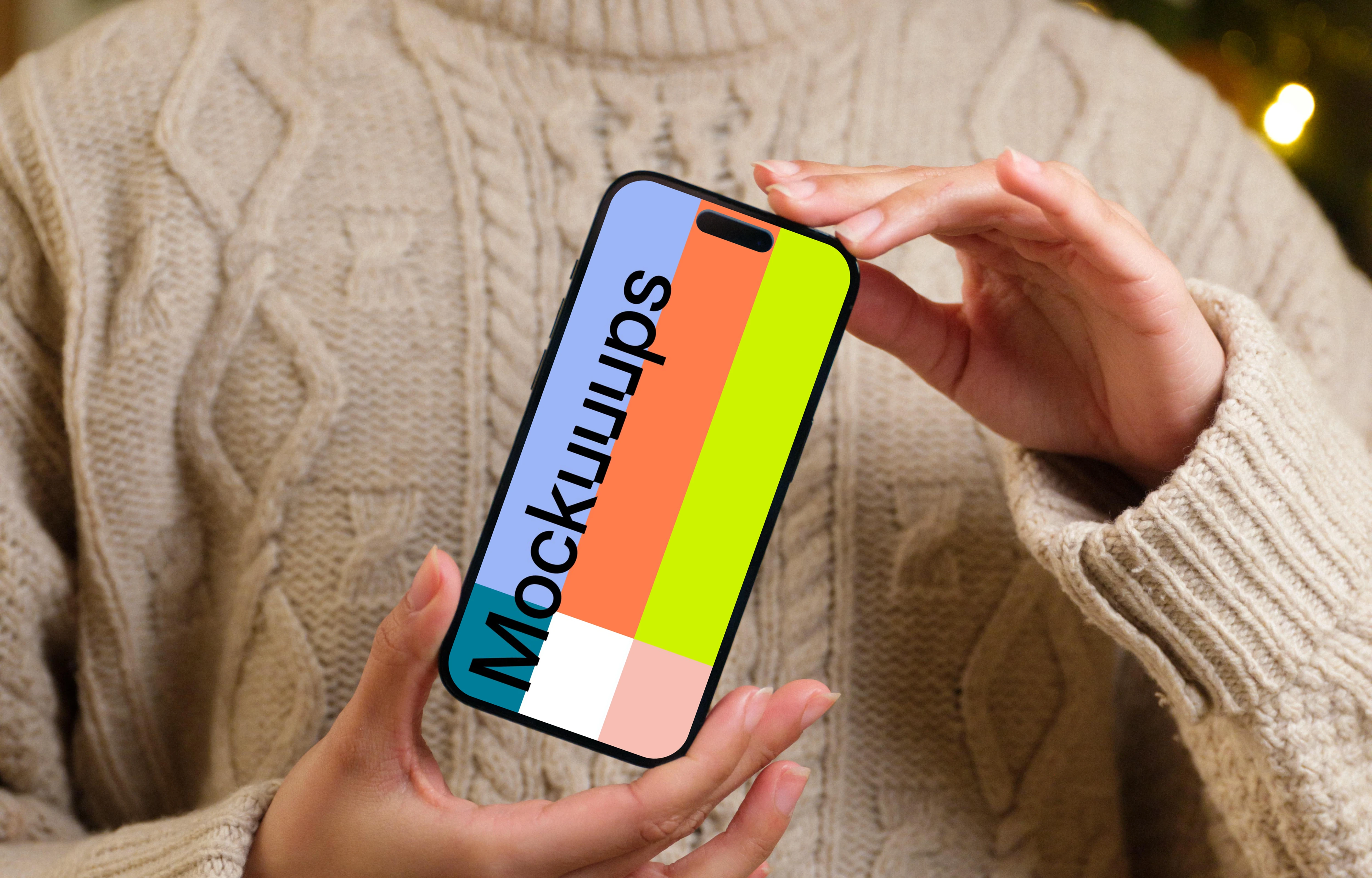 Woman holding an iPhone 14 Pro mockup next to the Christmas tree
