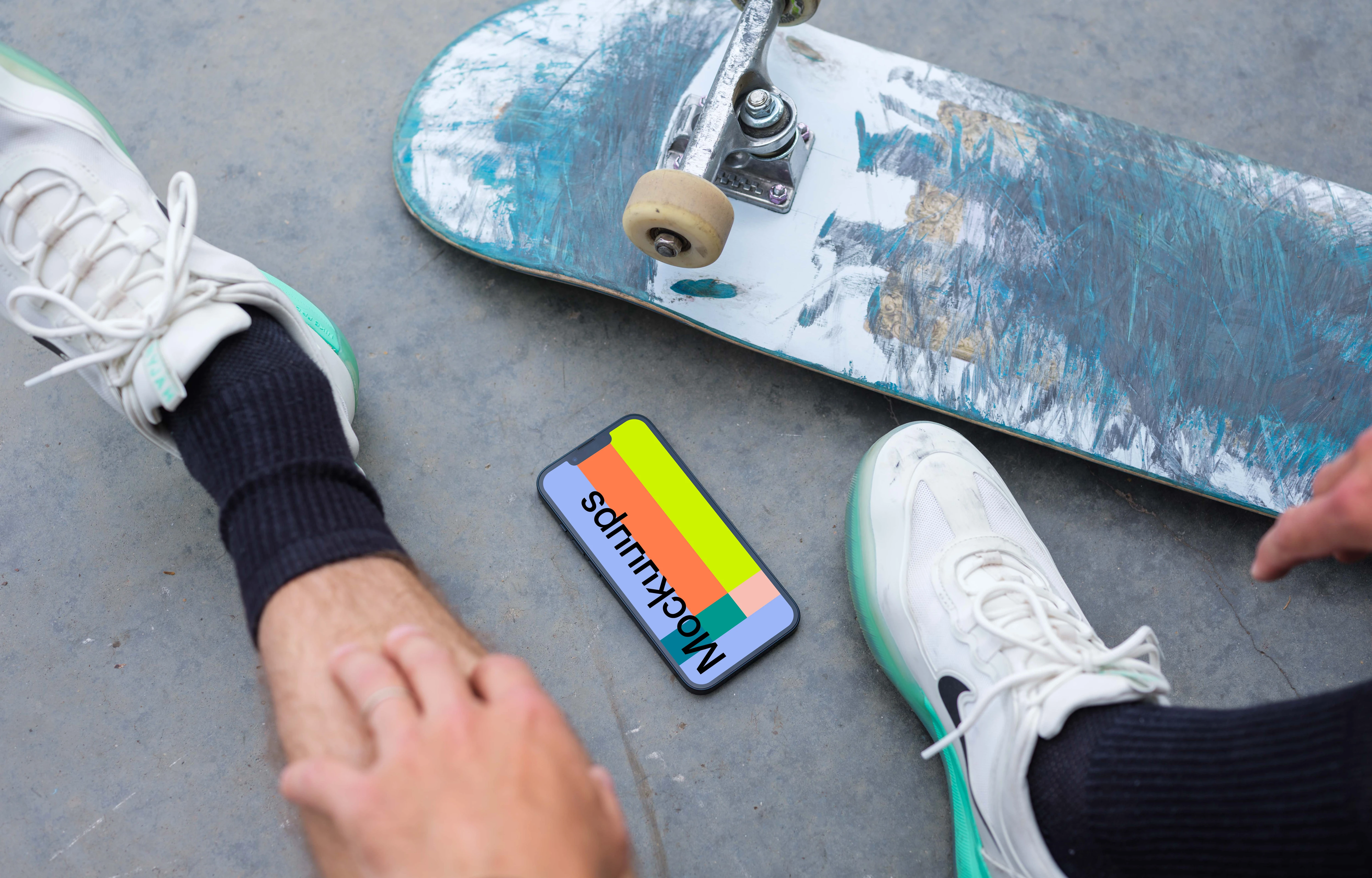 Skateboarder sitting next to an iPhone 13 mockup