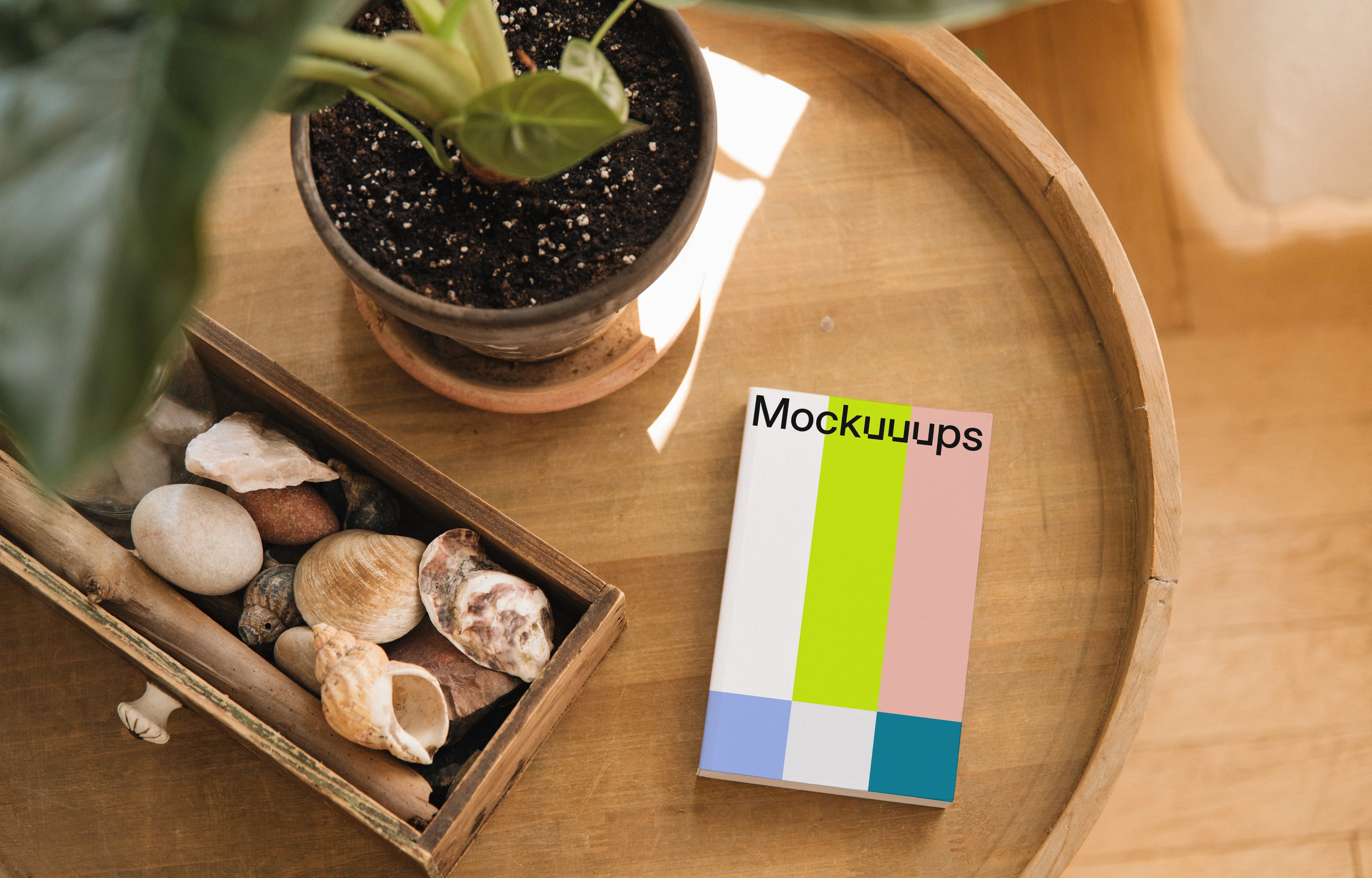 Softcover book mockup on a wooden table with decor