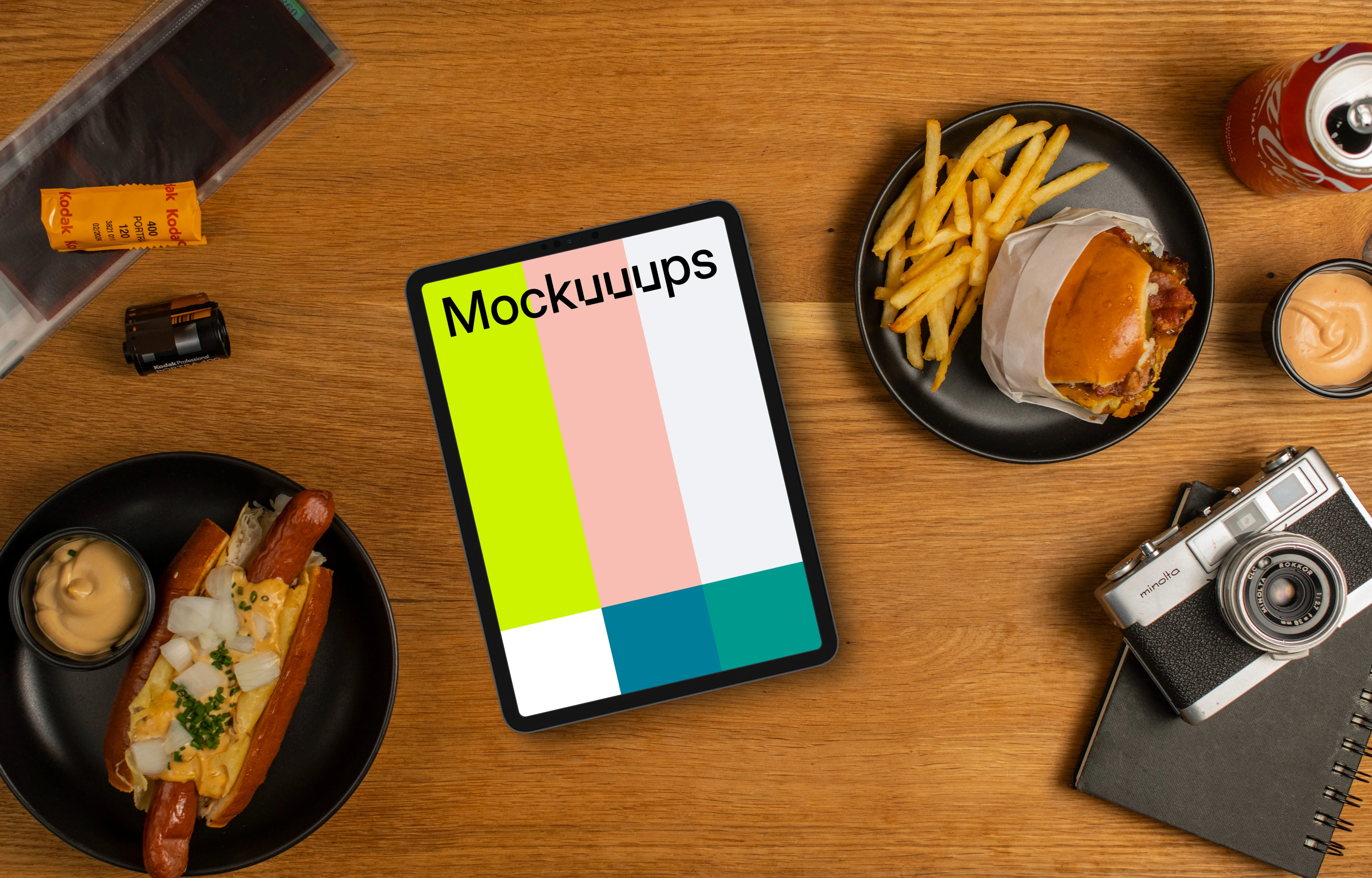 Tablet mockup between plates with hot-dogs