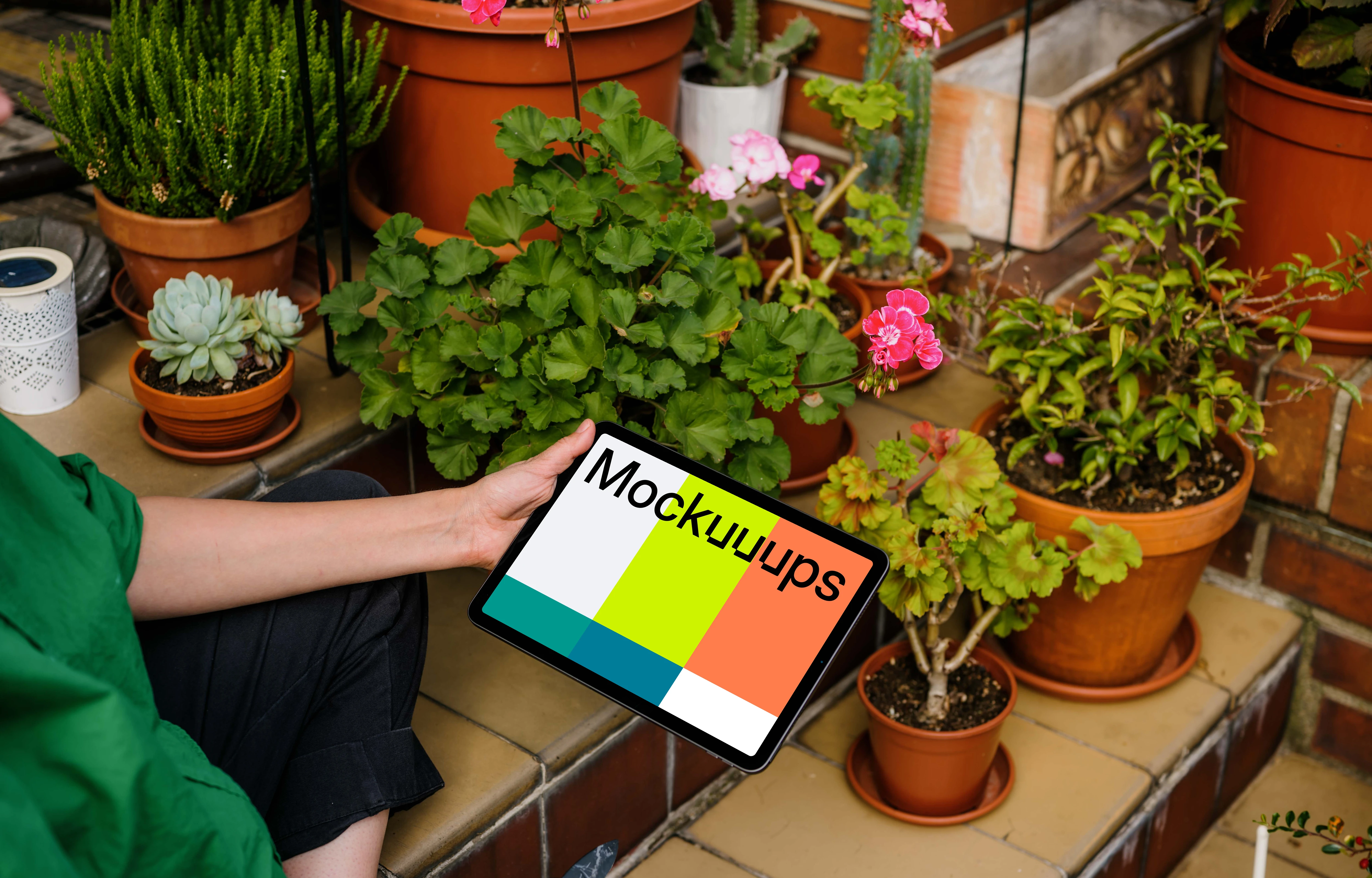 Woman holding an iPad Air mockup and taking care of flowers