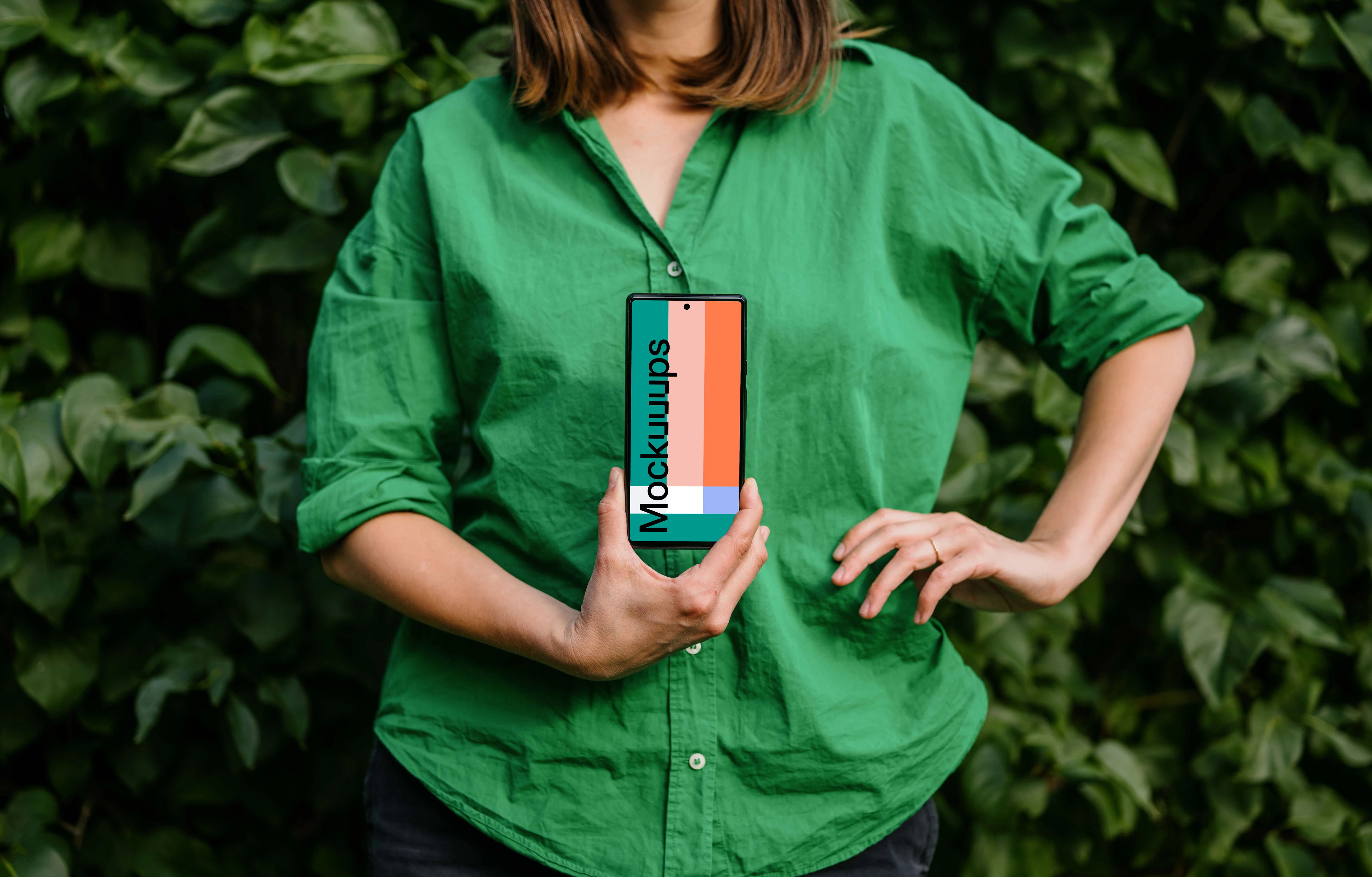 Woman in green environment holding a phone mockup 