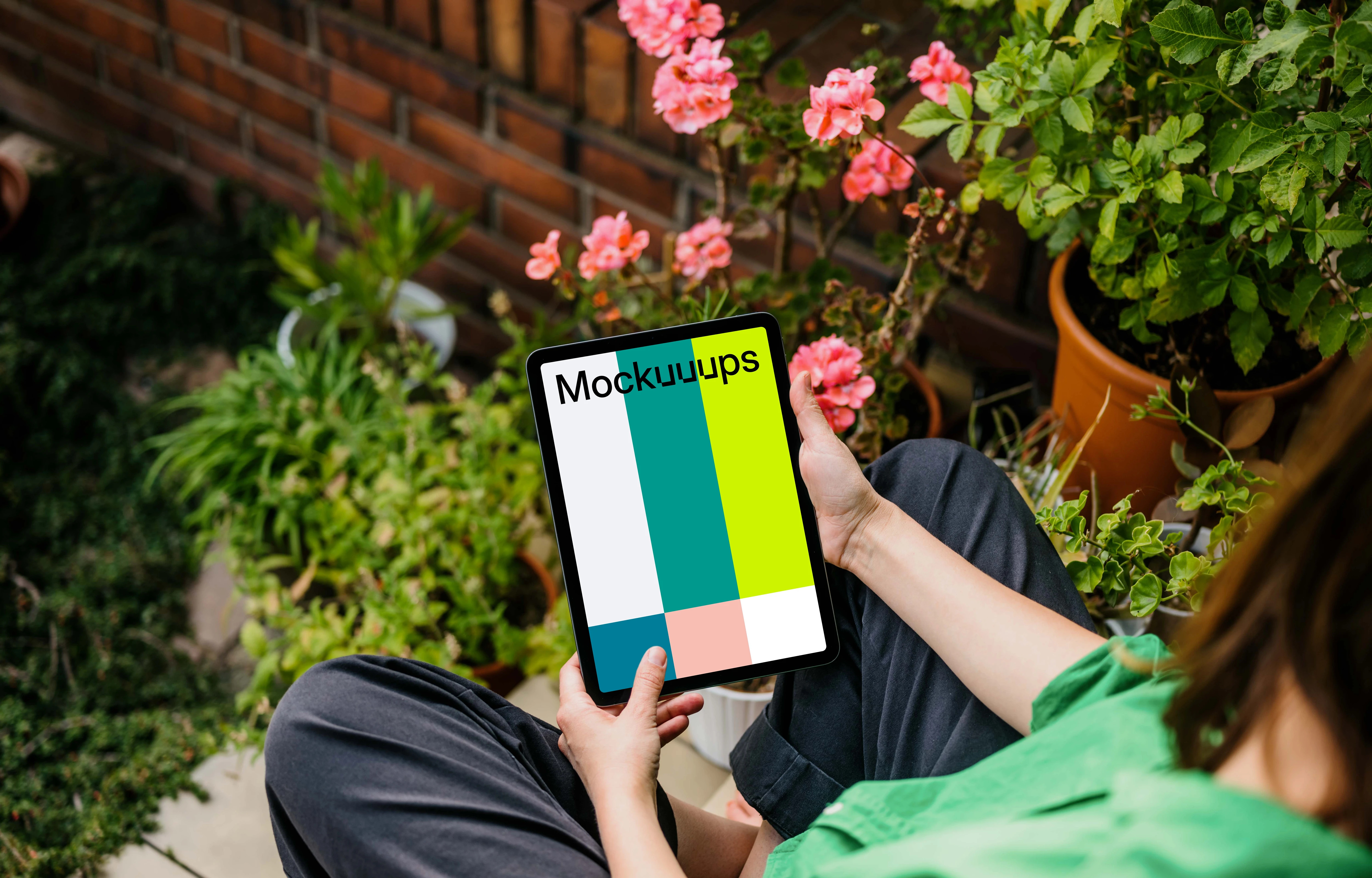Woman sitting in garden while holding an iPad Air mockup